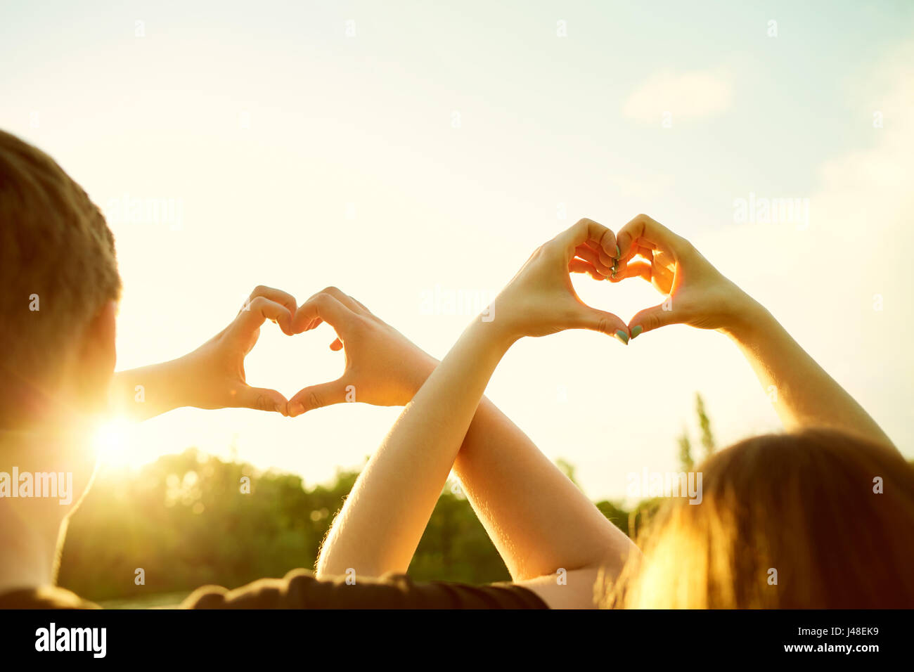 Couple aimant fait un symbole de l'amour coeur avec leur silhouette Banque D'Images
