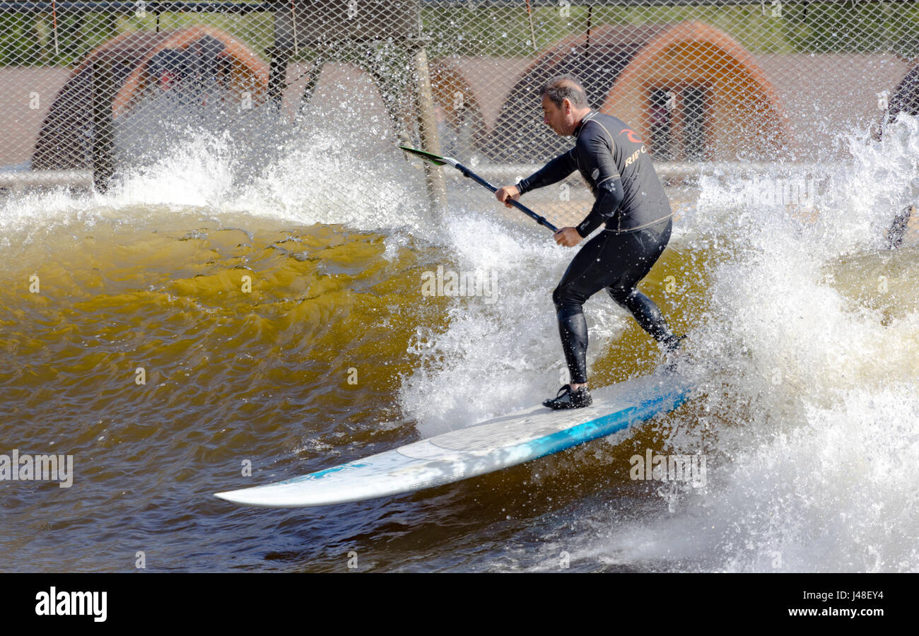 Paddle Surf à un pensionnaire de la piscine à vagues artificielles dans la vallée de Conwy sait aussi surfer sur Snowdonia, qui est le premier lac surf commerciale Banque D'Images
