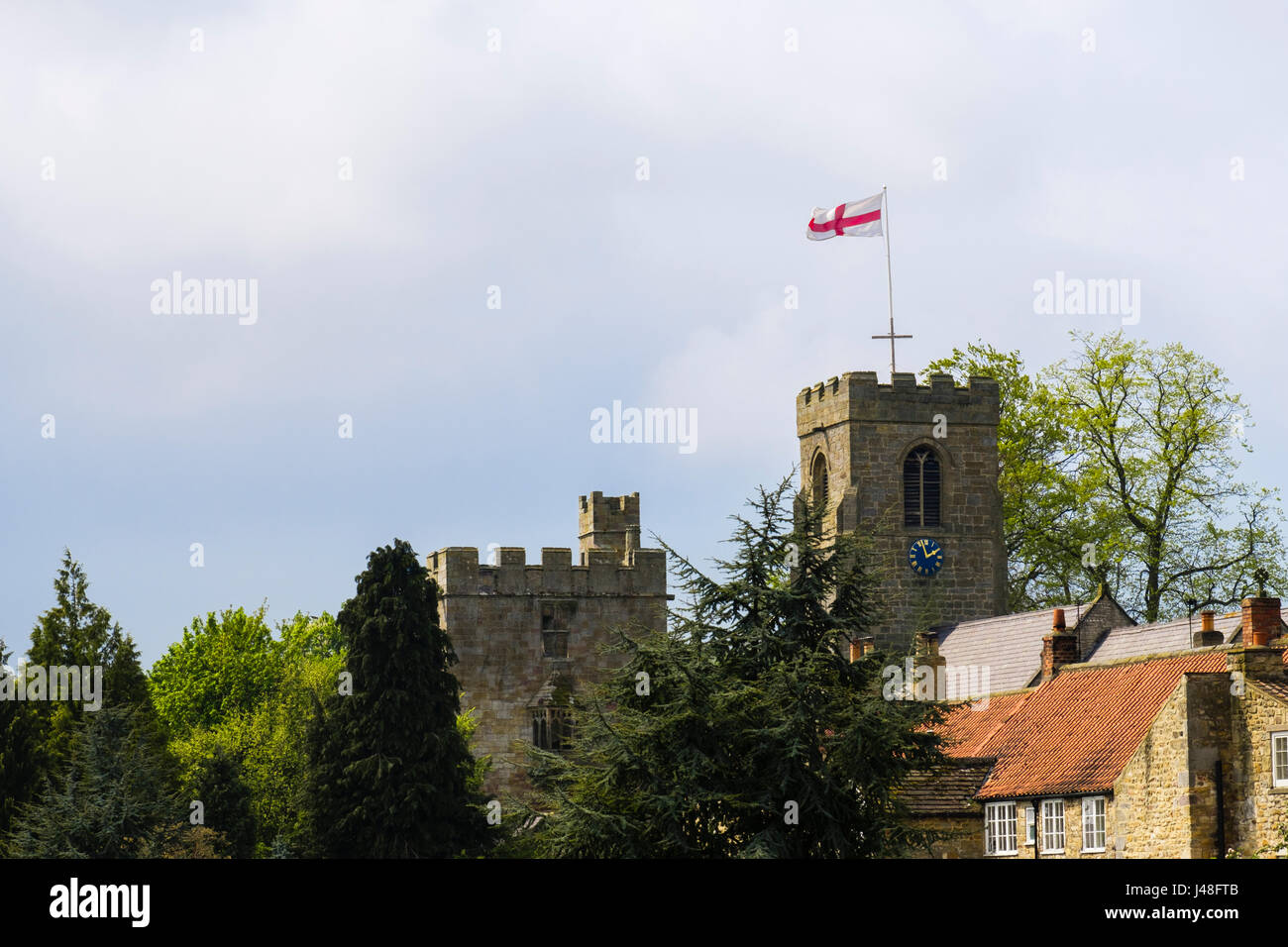 Drapeau anglais sur l'église St Nicolas du 15ème siècle à côté de la tour-porche de Marmion manoir perdu. Tanfield ouest au nord Yorkshire Angleterre Royaume-uni Grande-Bretagne Banque D'Images