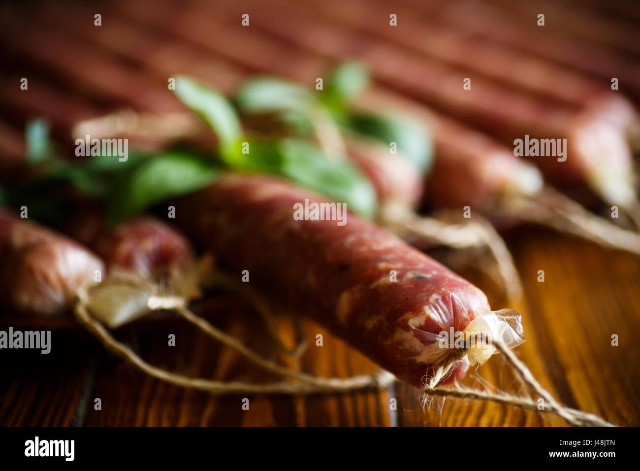 Saucisse maison biologiques crus fabriqués à partir de viandes naturelles sur une table en bois Banque D'Images