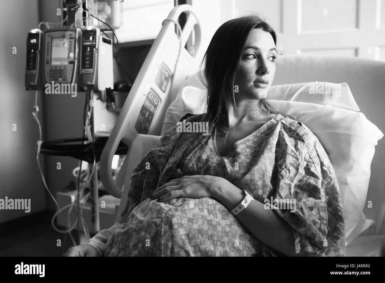 Une femme enceinte se trouve dans un lit d'hôpital en regardant par la fenêtre, Oregon, United States of America Banque D'Images