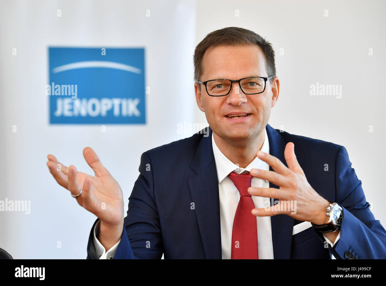 Jena, Allemagne. Le 11 mai, 2017. Stefan Traeger, nouveau président du conseil de surveillance lors de Jenoptik AG, représenté à la face d'un logo d'entreprise à Jena, Allemagne, 11 mai 2017. Photo : Martin Schutt/dpa-Zentralbild/dpa/Alamy Live News Banque D'Images