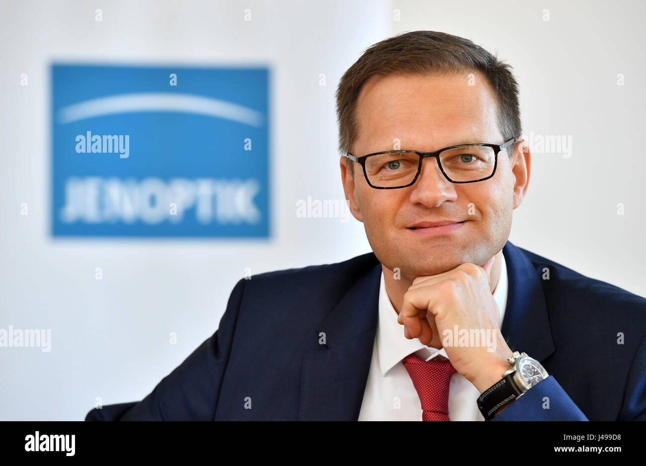 Jena, Allemagne. Le 11 mai, 2017. Stefan Traeger, nouveau président du conseil de surveillance lors de Jenoptik AG, représenté à la face d'un logo d'entreprise à Jena, Allemagne, 11 mai 2017. Photo : Martin Schutt/dpa-Zentralbild/dpa/Alamy Live News Banque D'Images