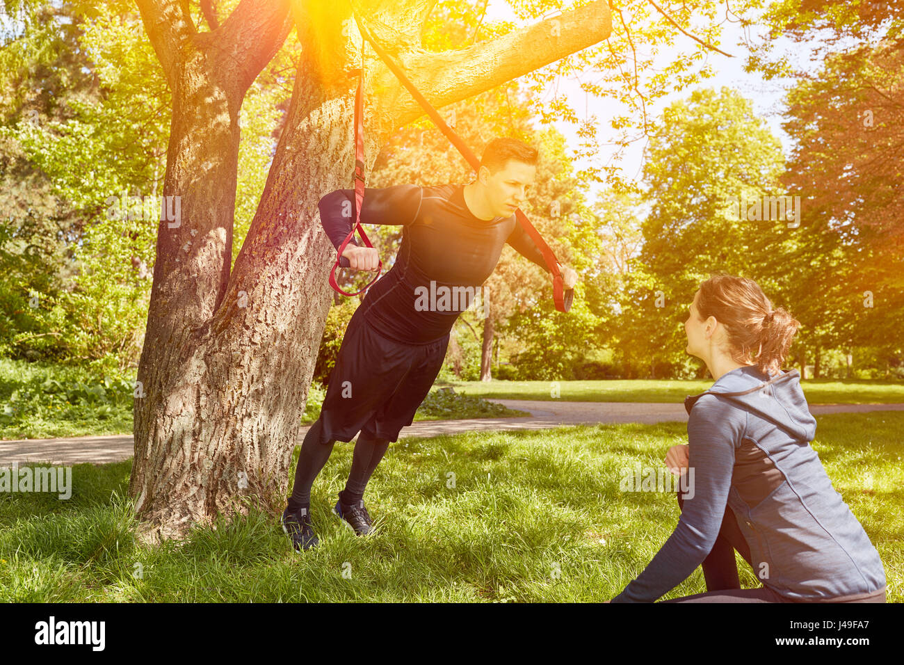Entraîneur personnel avec l'homme au parc fitness training with sling Banque D'Images