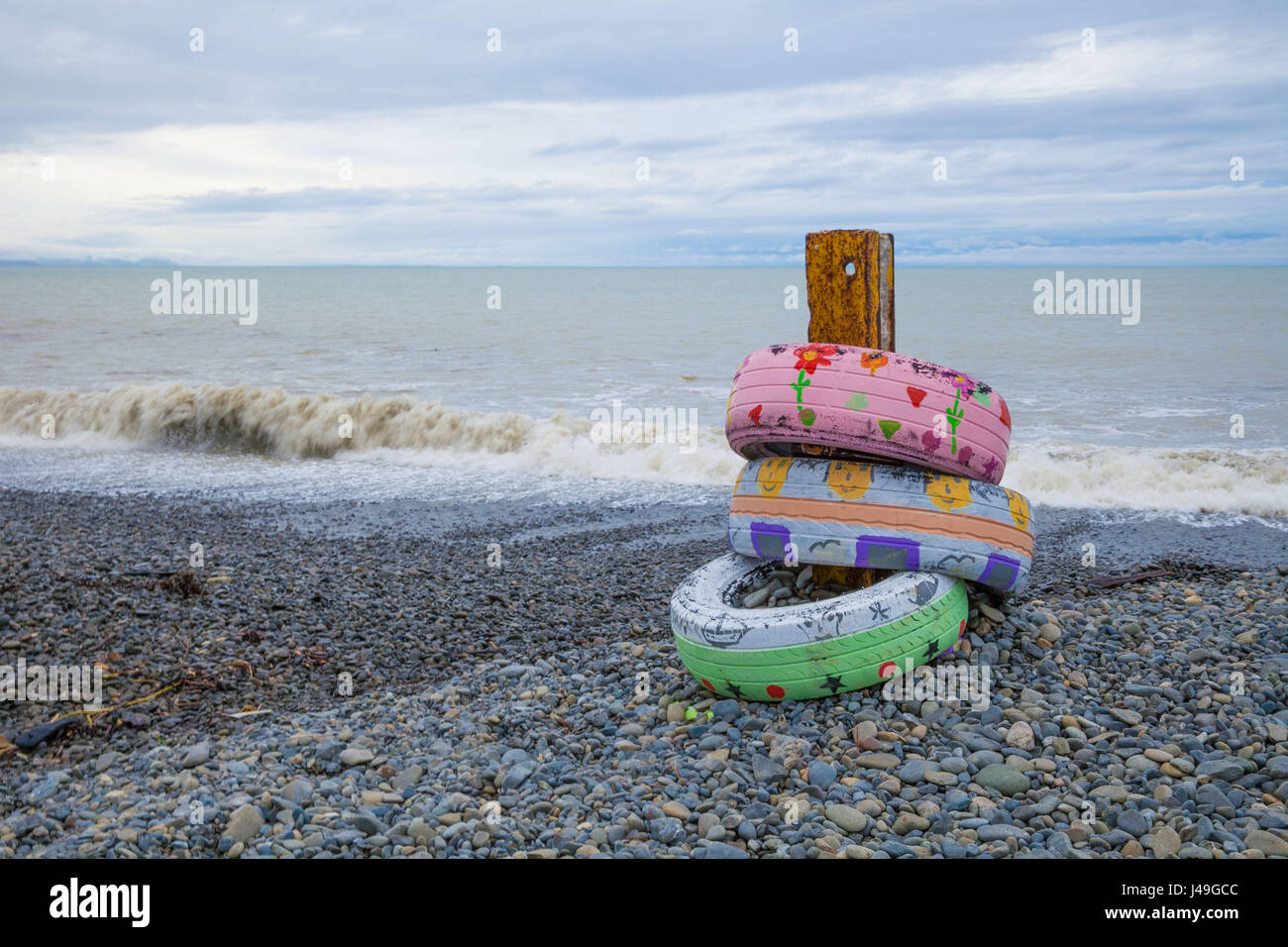 Pneus décorés sur une plage de galets en hiver Banque D'Images