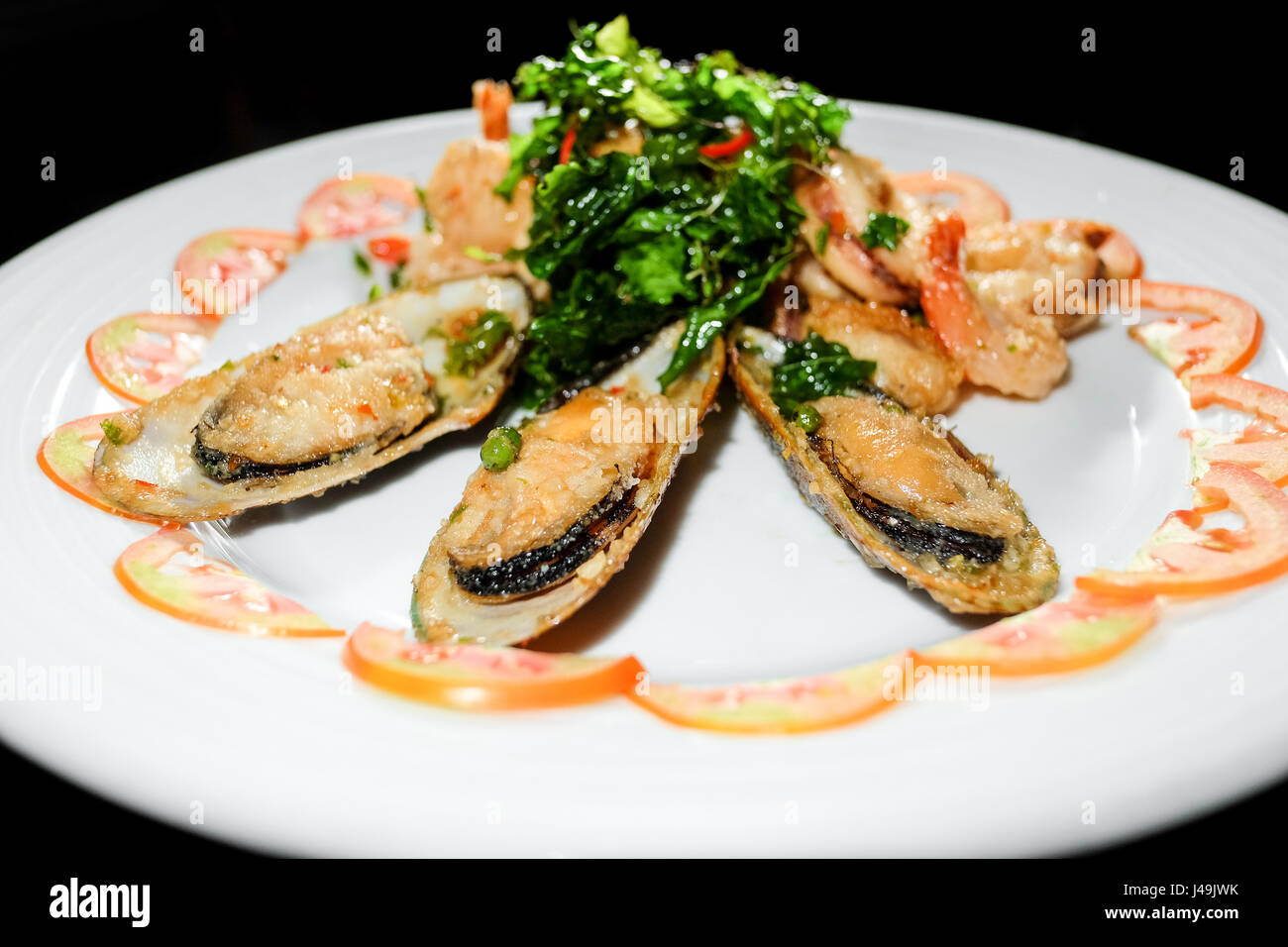 Assiette de style asiatique avec des pétoncles sésame et gingembre sauce hoisin et les brochettes de crevettes en fond noir Banque D'Images