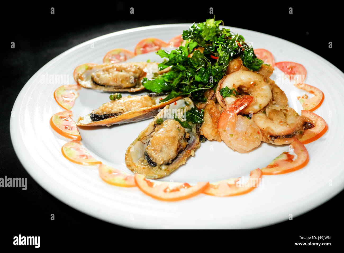 Assiette de style asiatique avec des pétoncles sésame et gingembre sauce hoisin et les brochettes de crevettes en fond noir Banque D'Images