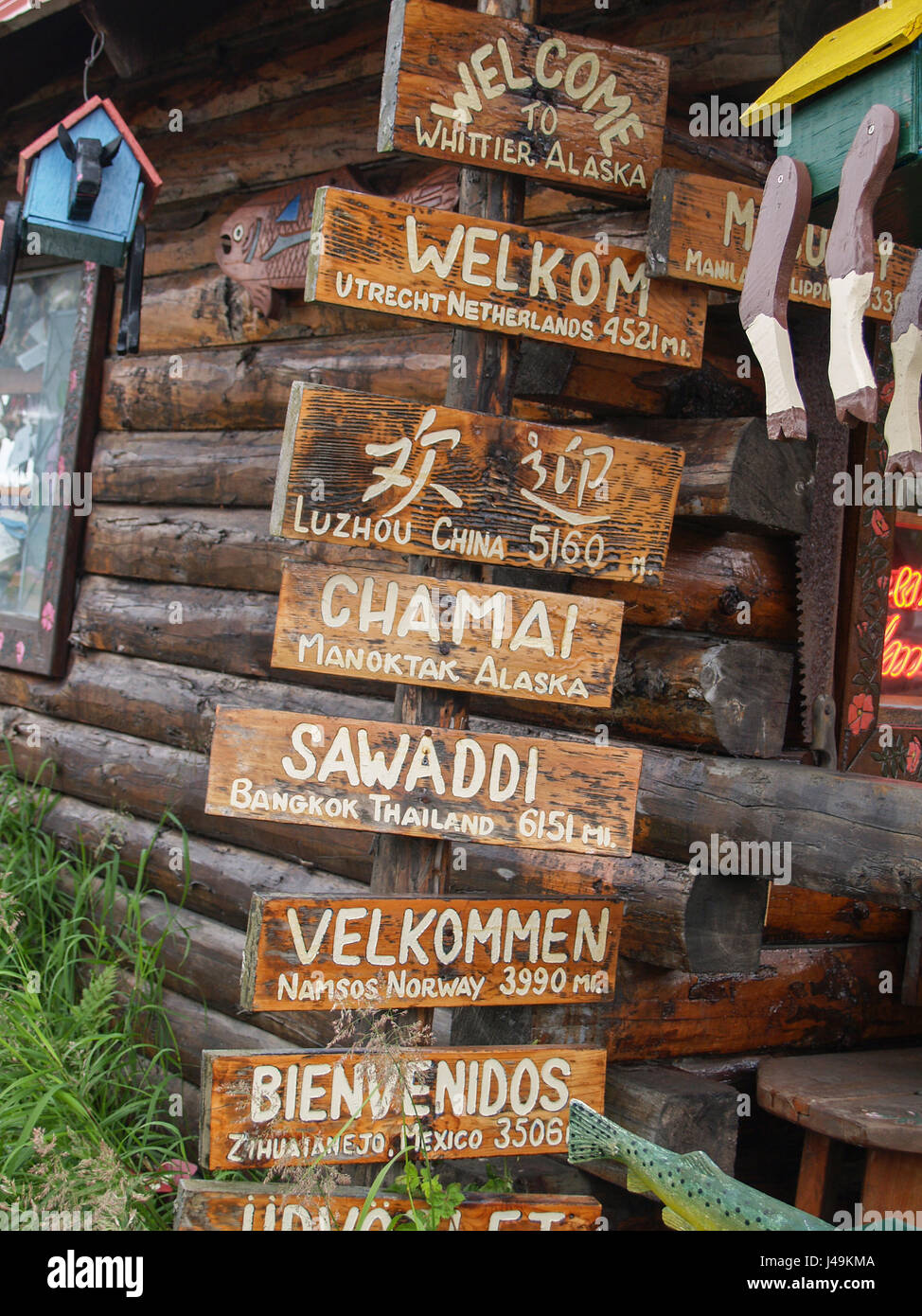 Panneau de bienvenue en plusieurs langues à l'extérieur de Log Cabin, boutique de cadeaux souvenirs pour touristes à Whittier en Alaska, USA. Banque D'Images