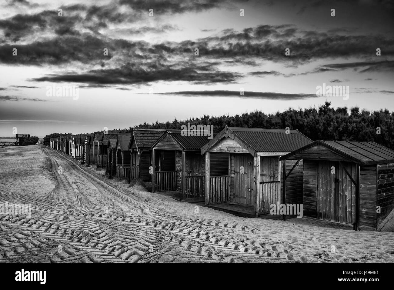 Beau lever du soleil d'hiver animée sur Plage avec cabines de plage disparaissant dans la distance Banque D'Images