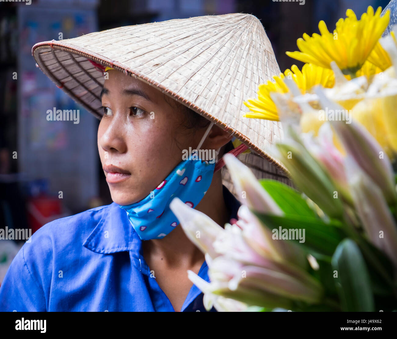 HANOI, VIETNAM - CIRCA SEPTEMBRE 2014 : Portrait de femme vietnamienne vente de fleurs dans les rues de Hanoi, Vietnam. Banque D'Images