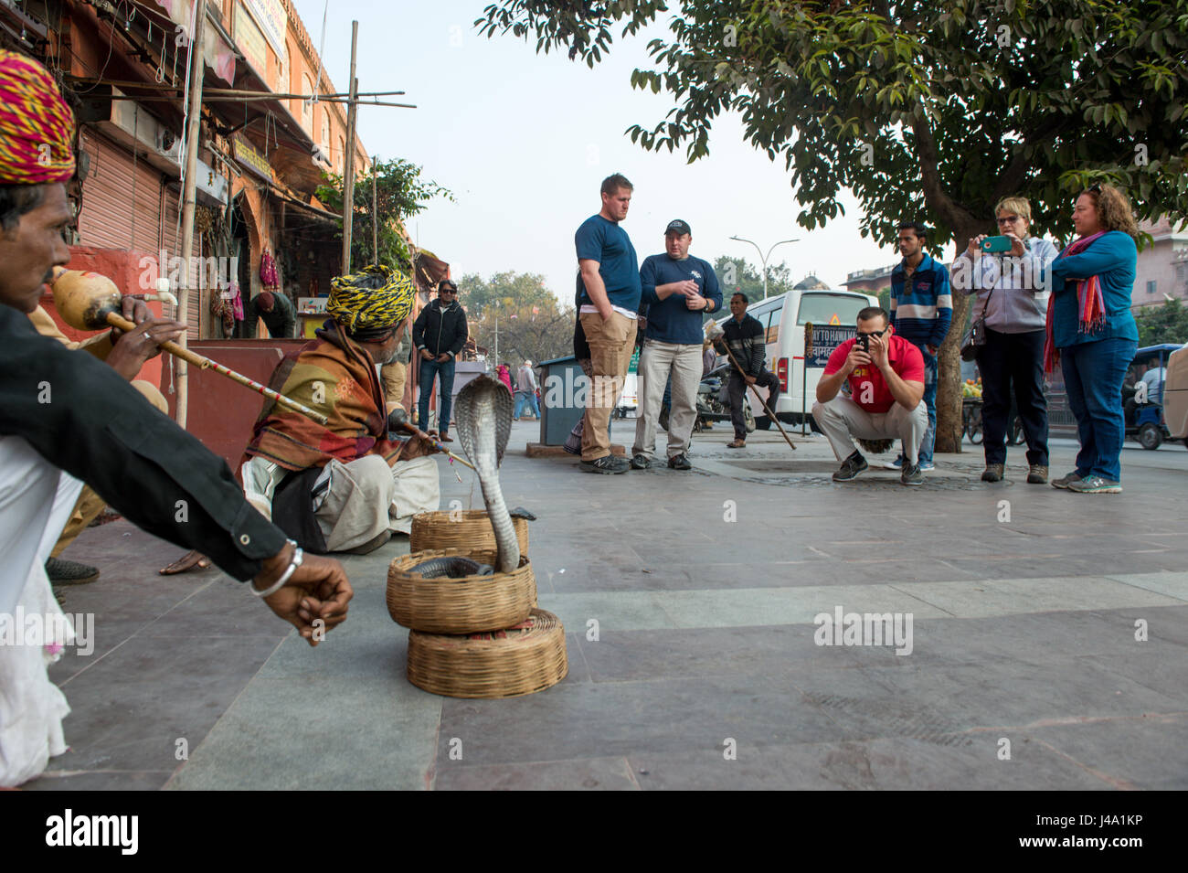 Les touristes regarder les charmeurs de serpent dans les rues de Jaipur, Inde. Banque D'Images