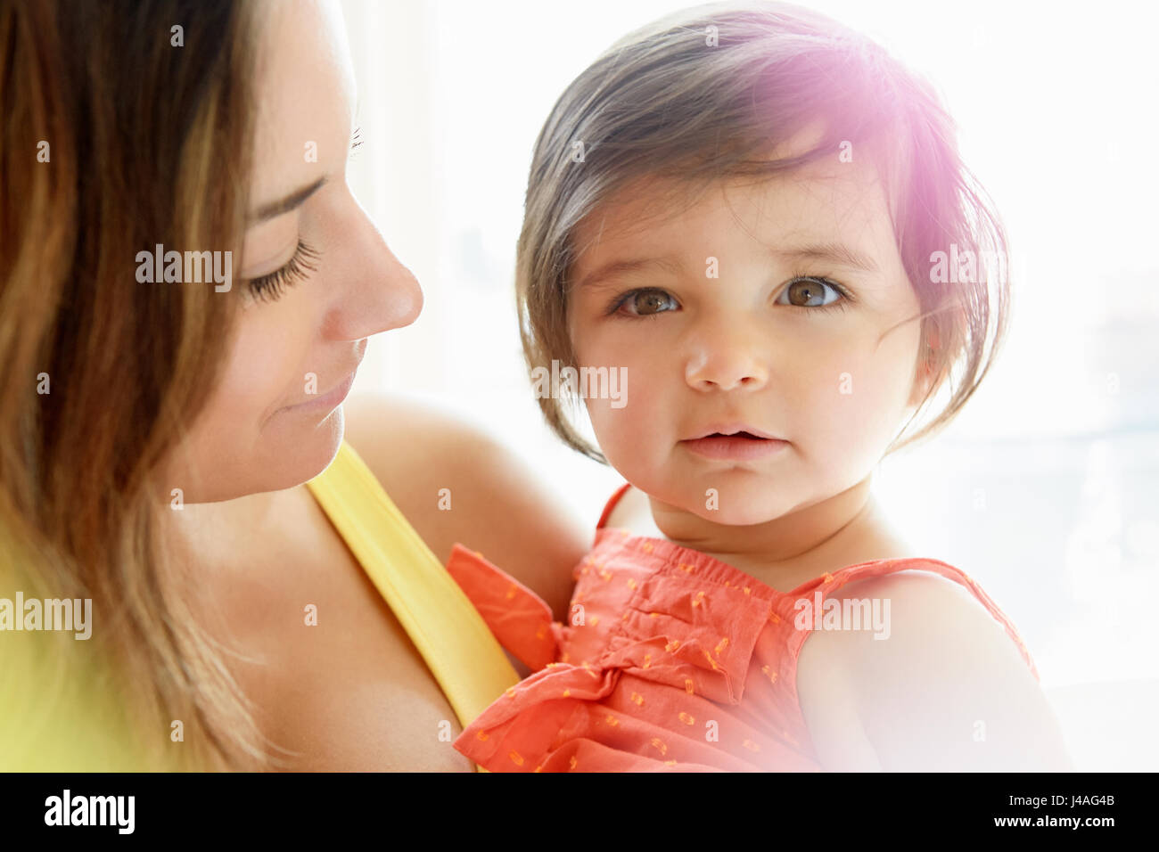 Baby Girl en cours dans les bras de mère Banque D'Images