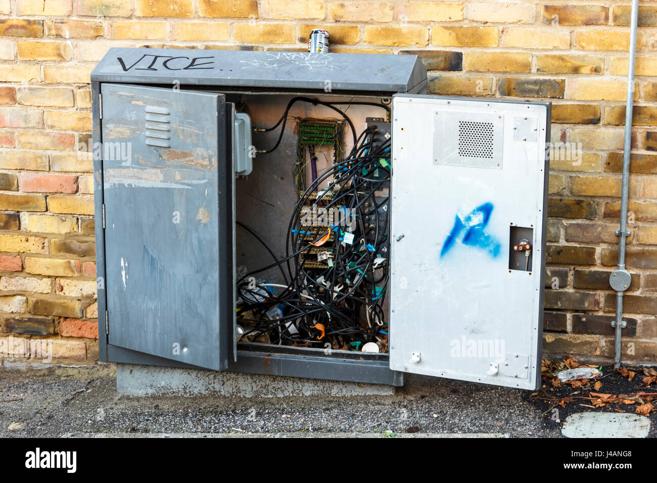 Une boîte de télécommunications avec la porte ouverte, montrant un enchevêtrement de fils et de câbles à l'intérieur, London, UK Banque D'Images