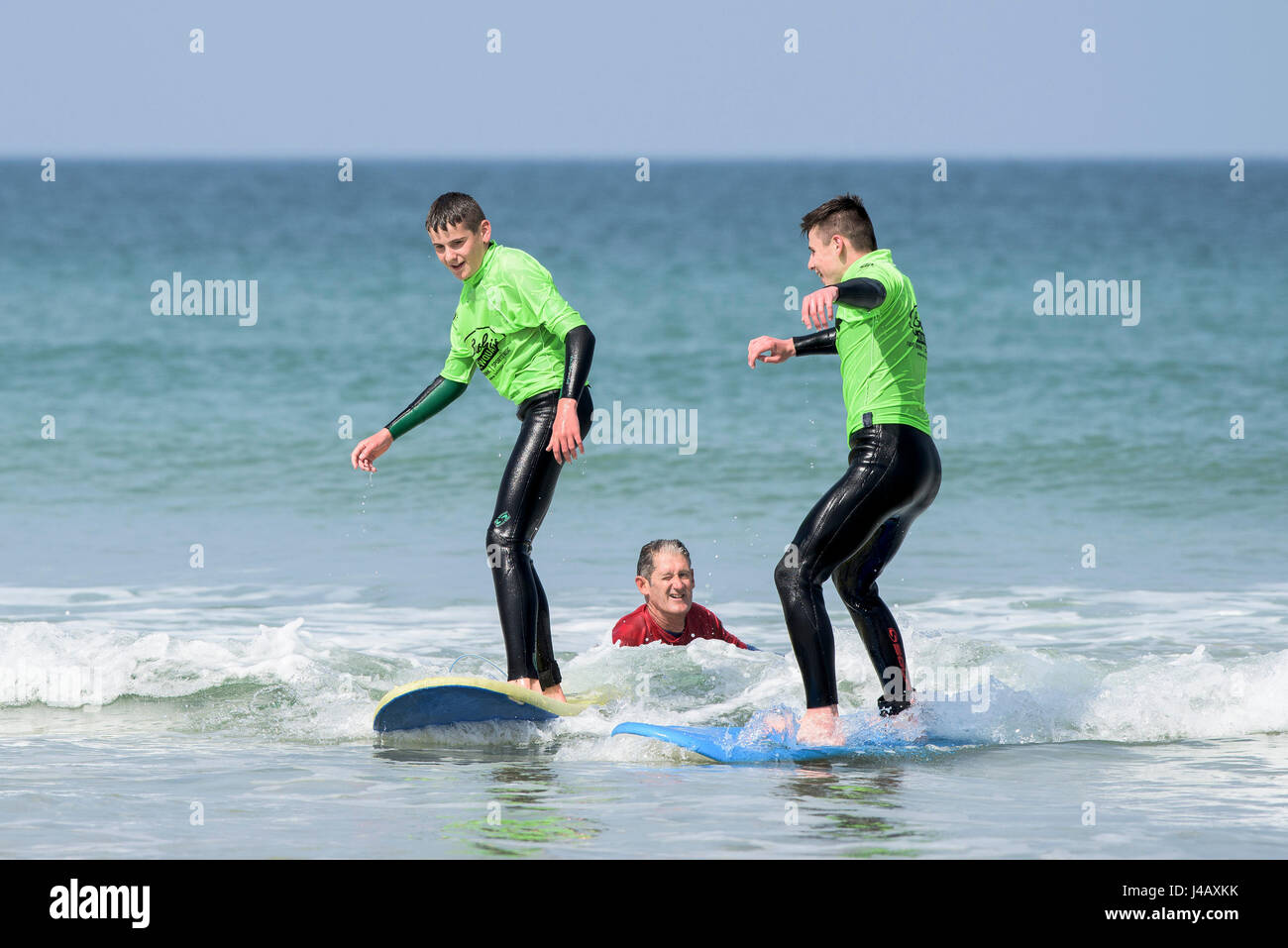 Novices apprendre à surfer sur la plage de Fistral Newquay Cornwall à échapper à l'école de surf surf Surfers Instructeur d'apprentissage des apprenants en bord de mer à Banque D'Images