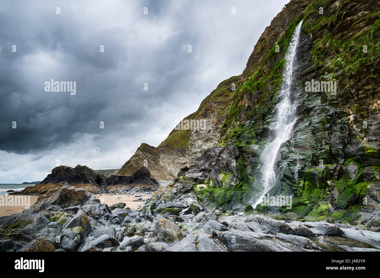 Cascade de la rivière parle l'écoule sur falaises sur la plage à Tresaith Bay, un village côtier de Ceredigion, pays de Galles. Banque D'Images