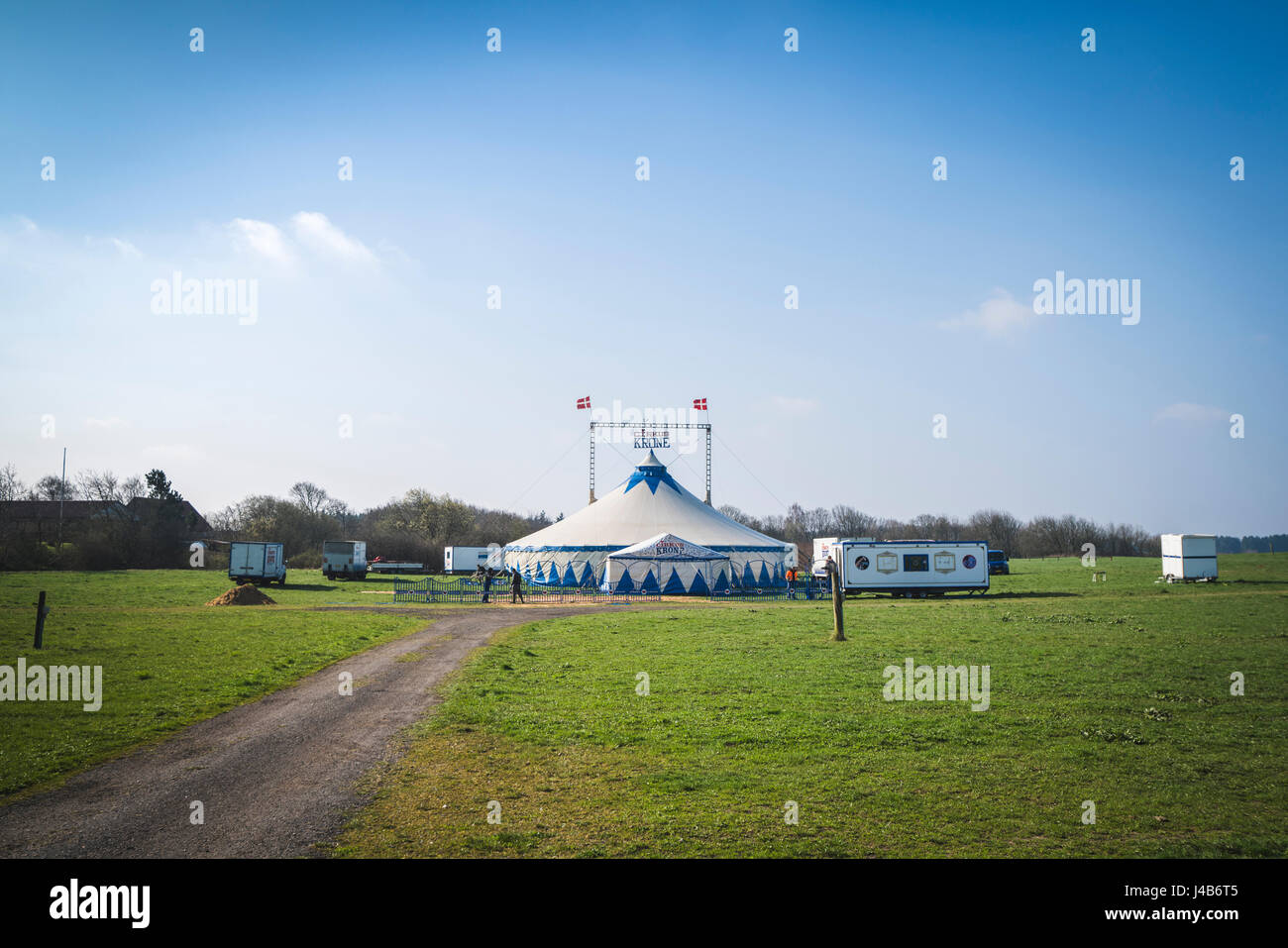 Entre eux, le Danemark - avril 9 - 2017 : la couronne de cirque la mise en place d'une tente sur un champ en eux avec les travailleurs de la création d'une clôture autour de c Banque D'Images