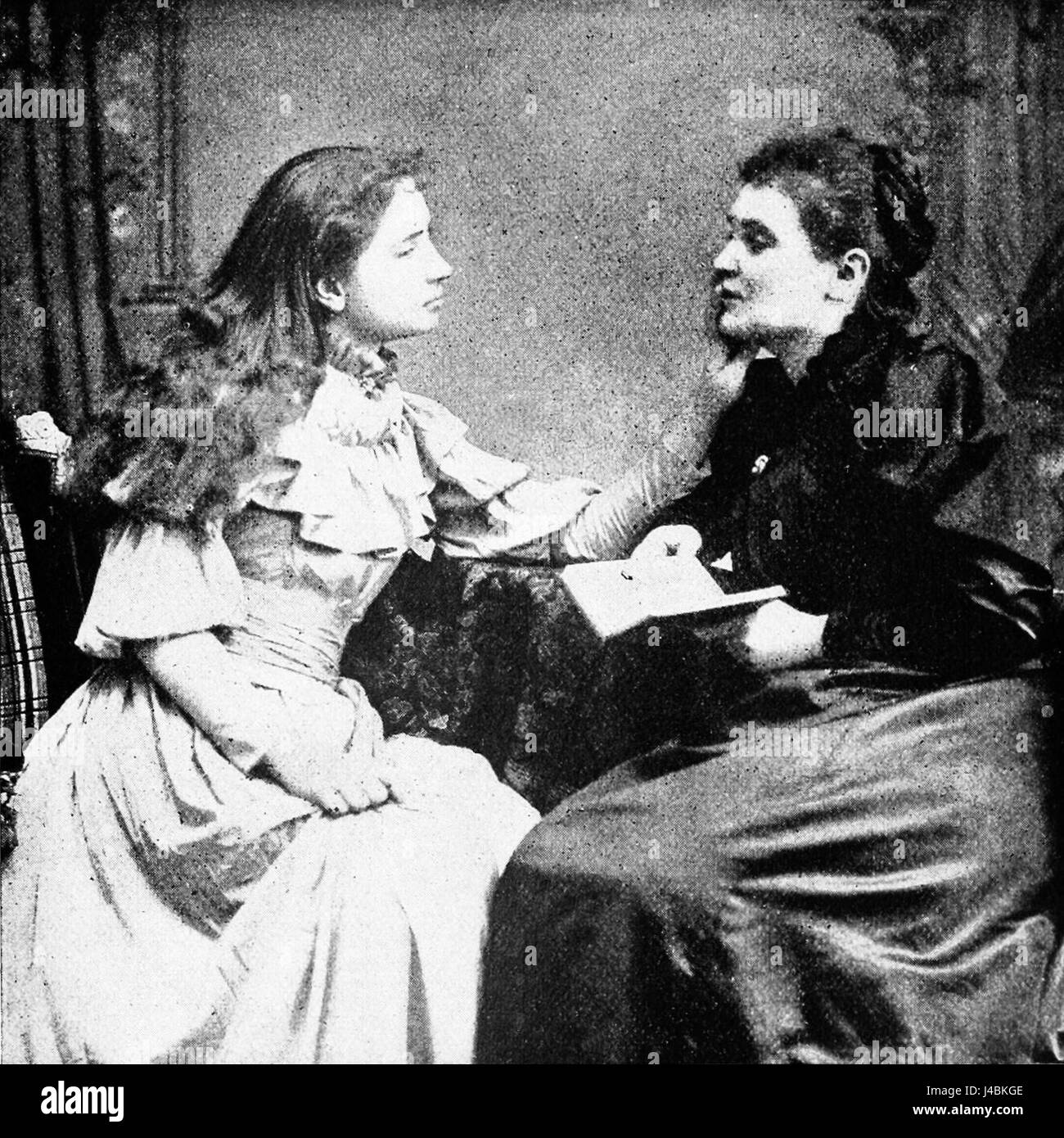 Cette image historique illustre Helen Keller avec son professeur, Anne Sullivan, soulignant leur remarquable parcours éducatif et la percée dans la communication pour les sourds-aveugles. Banque D'Images