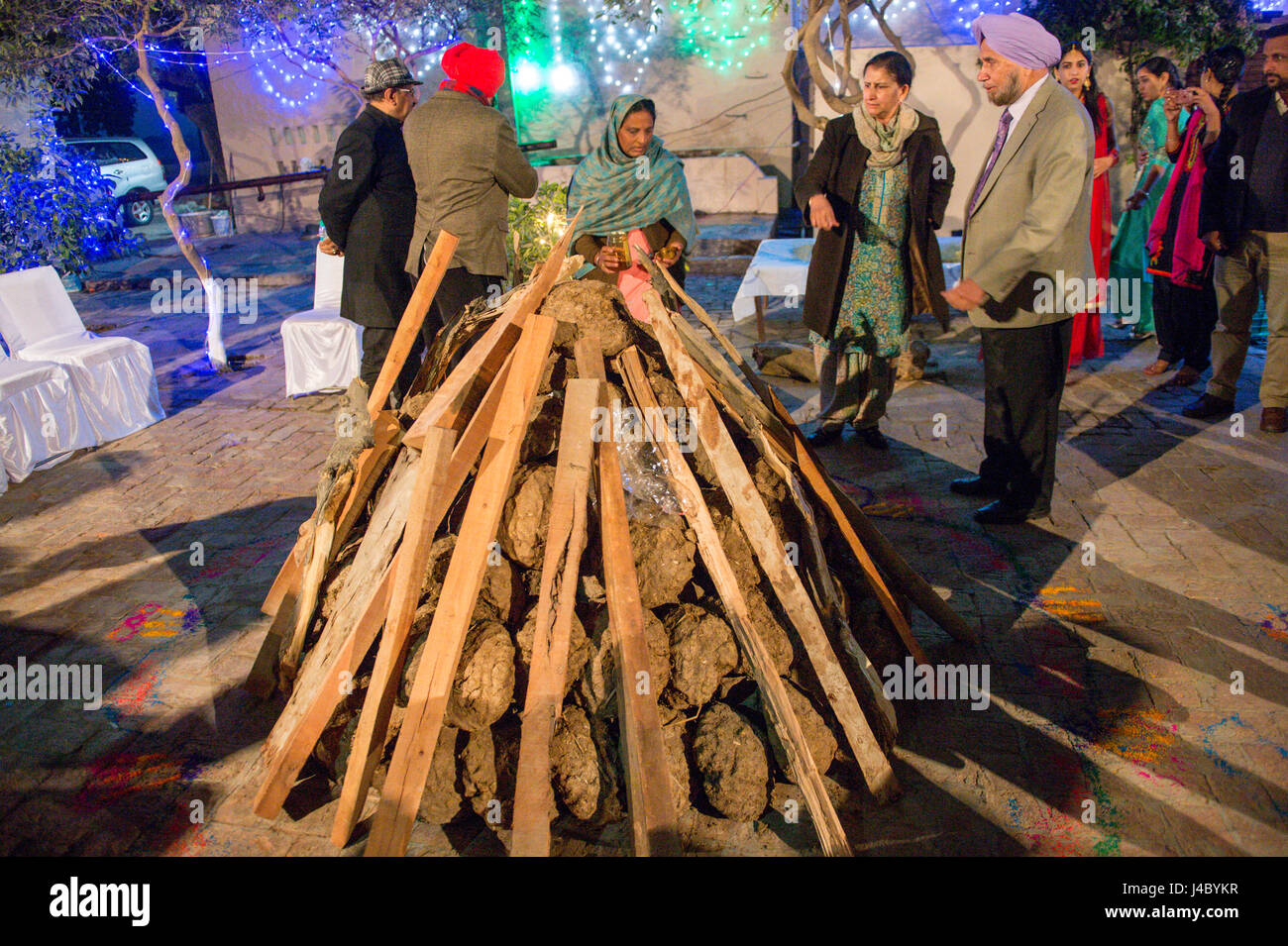 Le punjabi, hommes et femmes la préparation du grand feu de joie pour la Lohri célébration dans la province du Punjab, en Inde. Banque D'Images