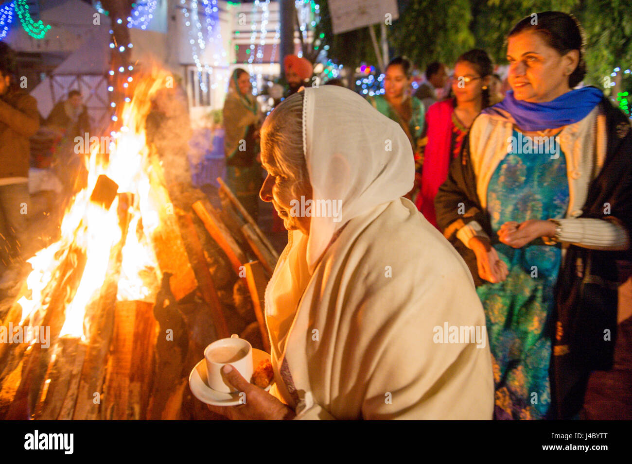 Les femmes Punjabi marche autour de la Lohri bonfire en maintenant des rafraîchissements et des graines dans la province du Punjab, en Inde. Banque D'Images