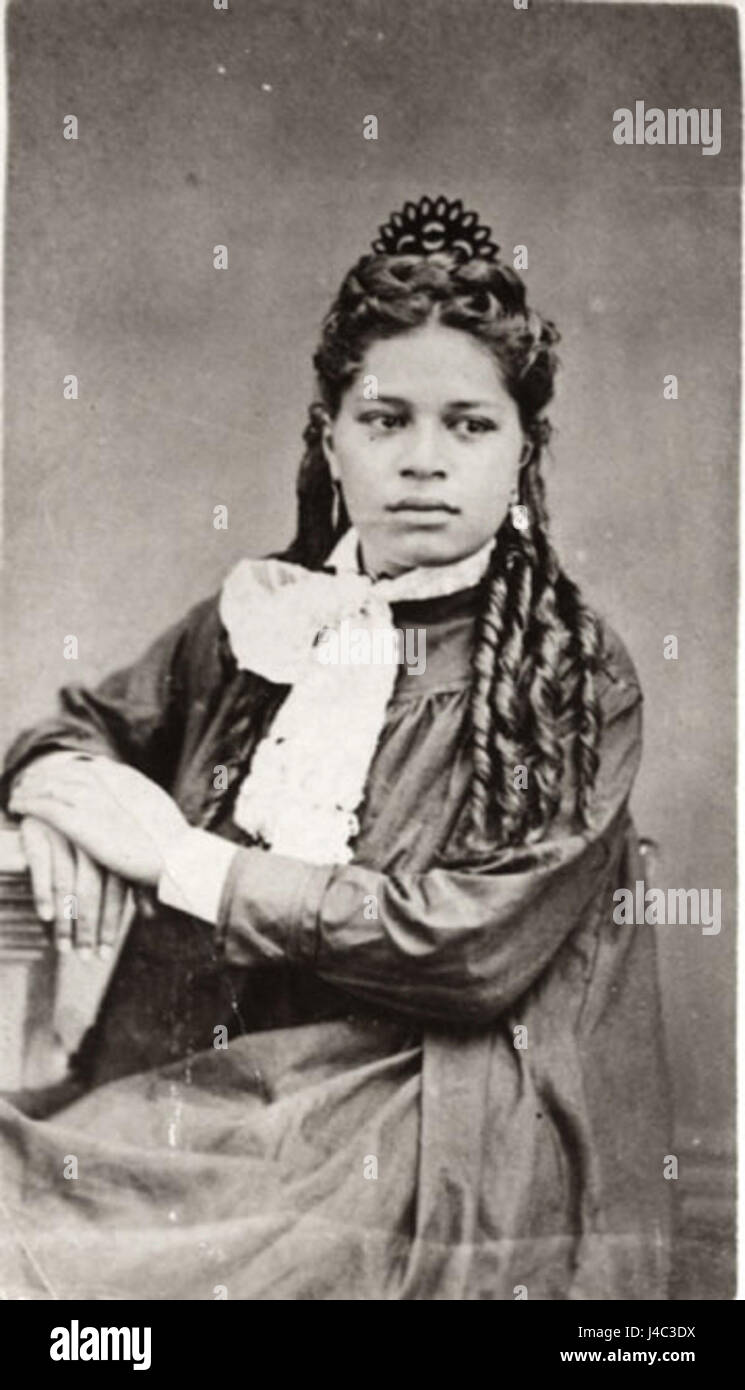 Voici une photographie d'une femme tahitienne, capturée par Madame Hoare. Le sujet est habillé de soie noire lourde, reflétant les pratiques artistiques et culturelles de l’époque. La photographie peut faire partie d’une étude ethnographique ou d’une exploration des cultures indigènes. Banque D'Images
