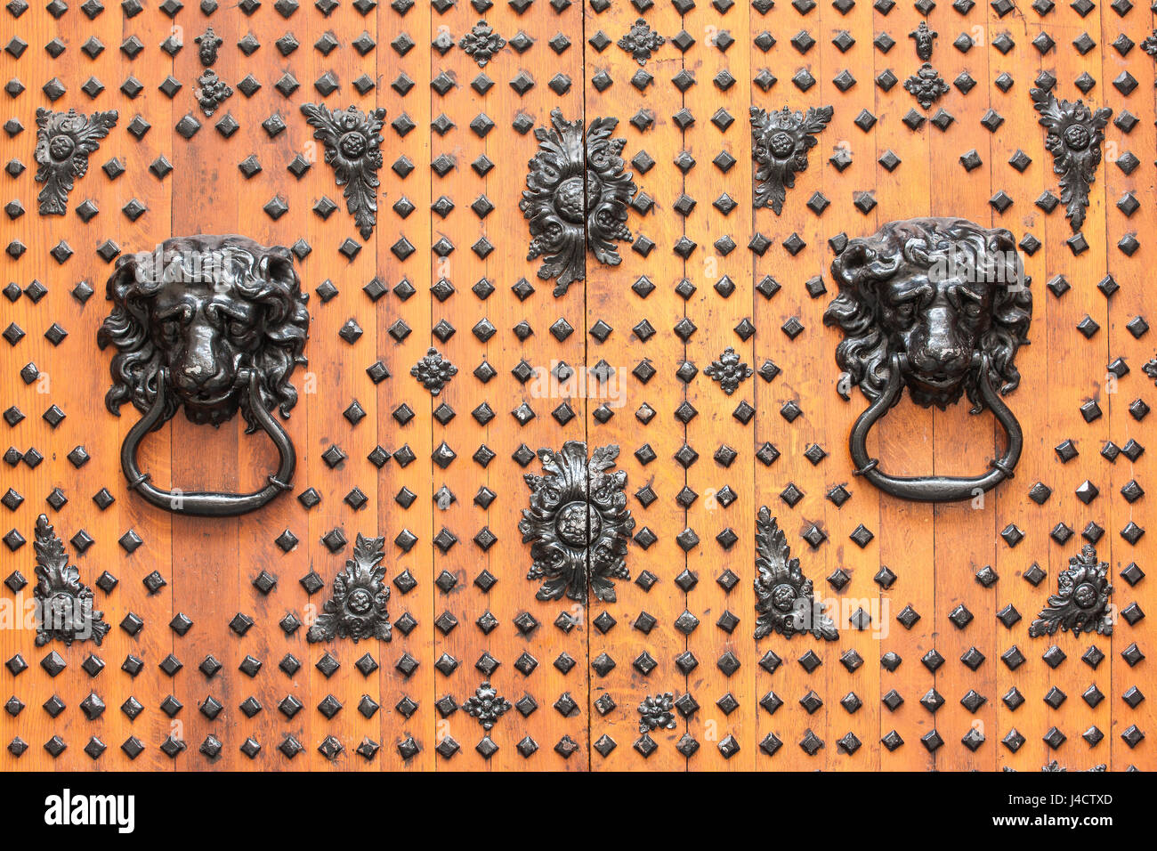 La décoration ouvragée heurtoirs de porte sur les grandes portes avant à St Nicolas, marché de Bristol. Banque D'Images