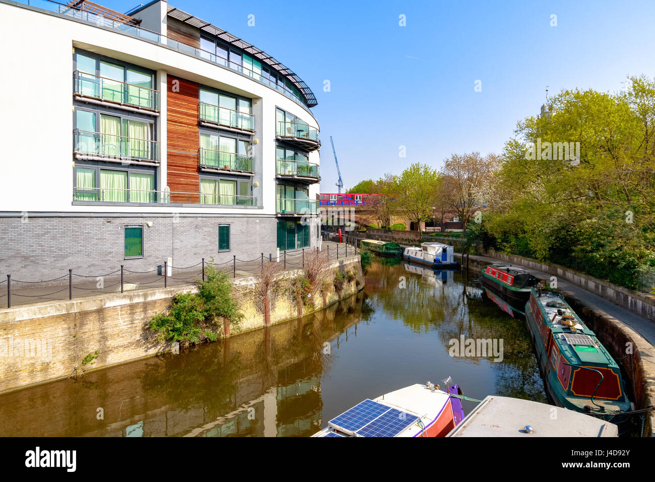 Waterside apartments à Limehouse Cut à Londres avec le Docklands Light Railway passent dans le fond Banque D'Images