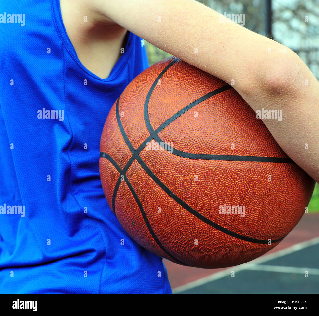 Basket-ball portant uniforme bleu et tenant la boule Banque D'Images