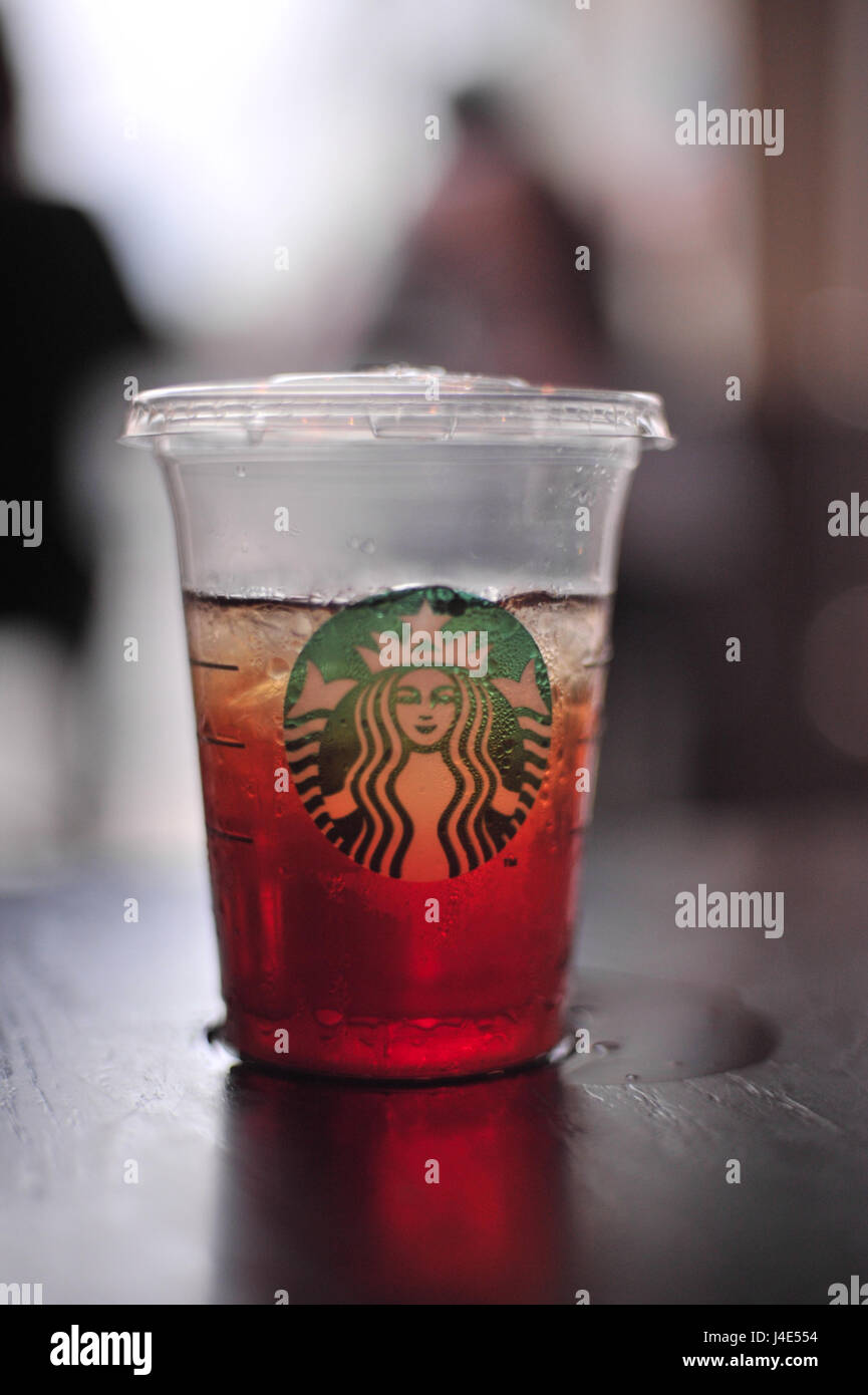 Une tasse en plastique de Starbucks dans le thé glacé, couverts et  ruisselant de gouttelettes avec de condensation. Un élément essentiel aux  photojournalistes travaillant hors d'un café comme ils le dossier images