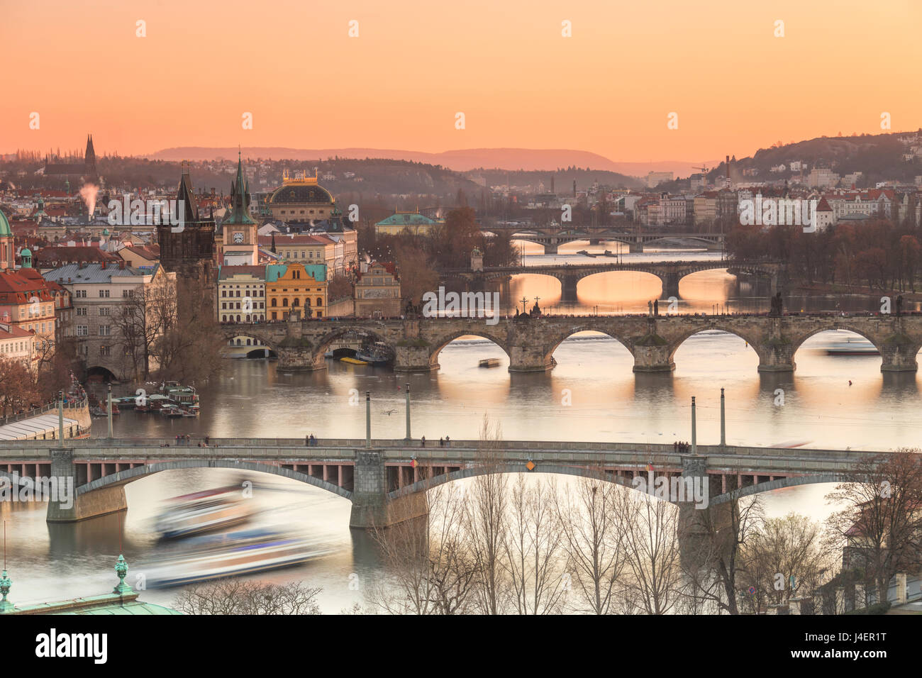 Ciel Orange au coucher du soleil sur les ponts et bâtiments historiques reflétés sur la rivière Vltava, Prague, République Tchèque, Europe Banque D'Images