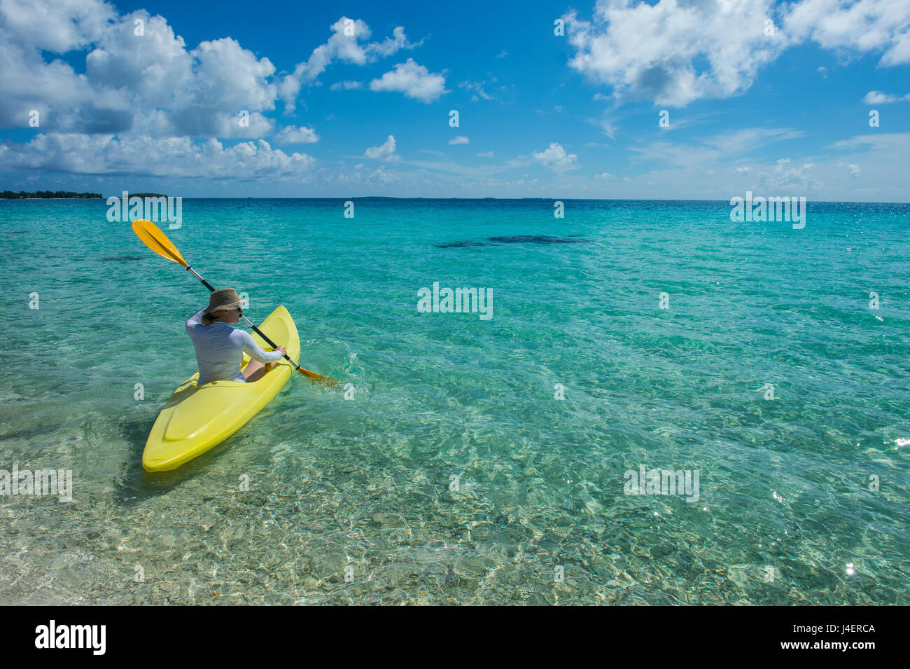 Femme kayak dans les eaux turquoises de Tikehau, Tuamotu, Polynésie Française, Pacifique Banque D'Images