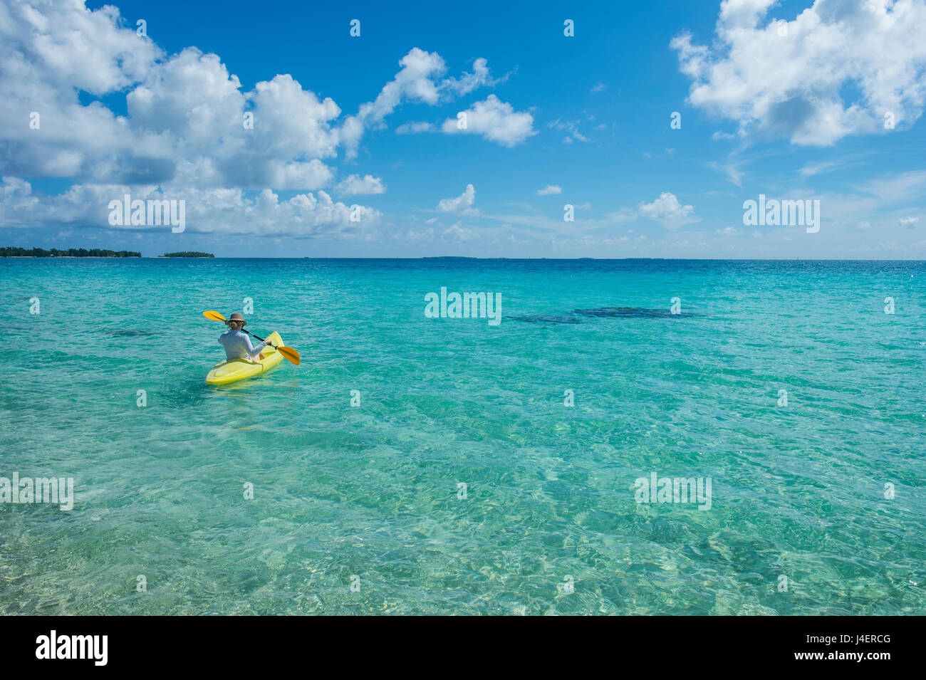 Femme kayak dans les eaux turquoises de Tikehau, Tuamotu, Polynésie Française, Pacifique Banque D'Images