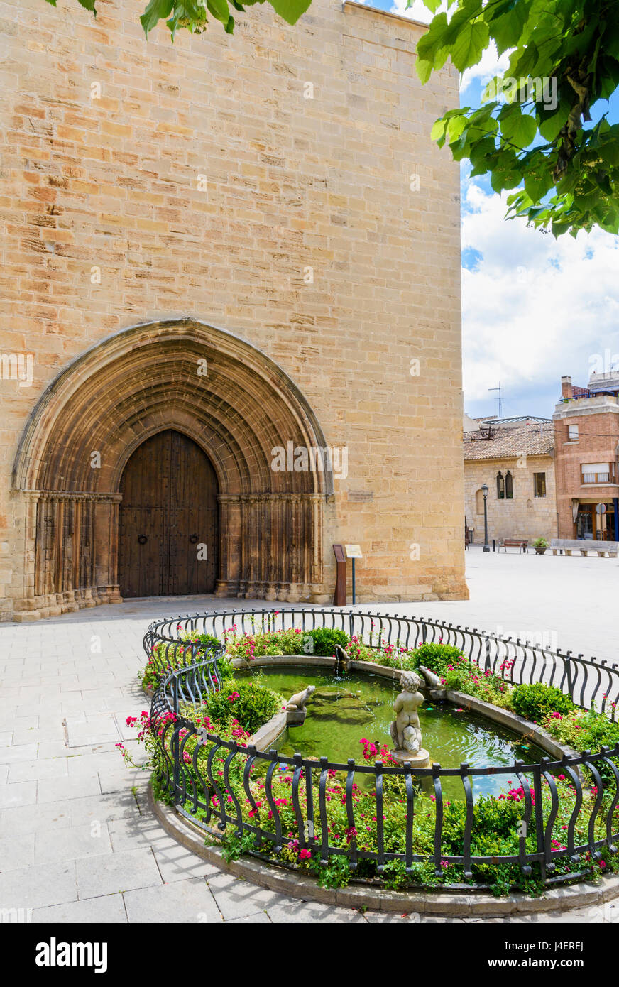 Étang fontaine ornementale et double porte en bois en dessous des archivoltes sur la façade de l'Esglesia Vella gothique de Sant Miquel, L'Espluga de Francoli Banque D'Images