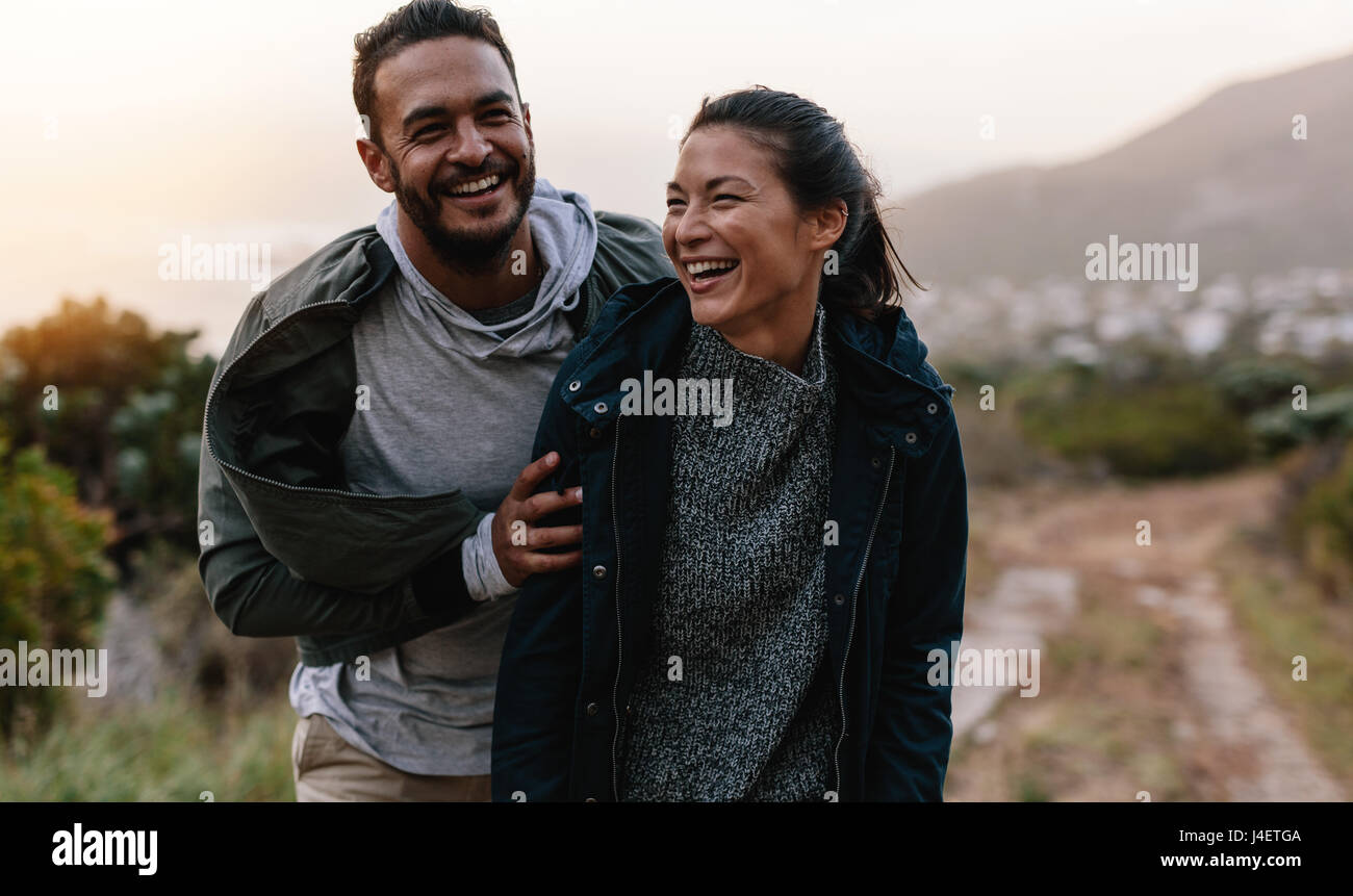 Portrait de couple en train de marcher à travers la montagne sur sentier. L'homme et la femme en vacances. campagne bénéficiant Les jeunes de la randonnée dans la nature. Banque D'Images
