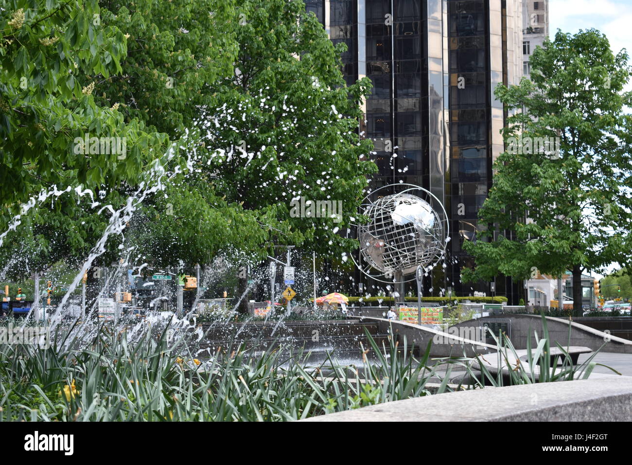 Globe à Columbus Circle est un globe en acier avec les 7 continents du monde entouré par 3 anneaux en acier extérieur vu par splash fontaine Banque D'Images