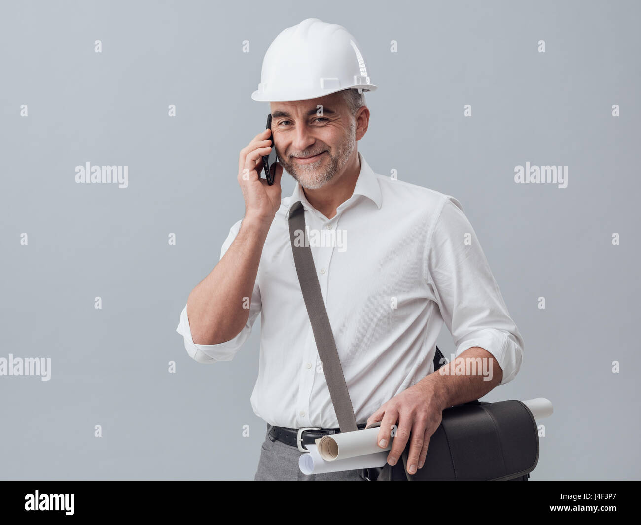 Ingénieur de construction à l'aide d'un smartphone, il est d'avoir un appel téléphonique Banque D'Images