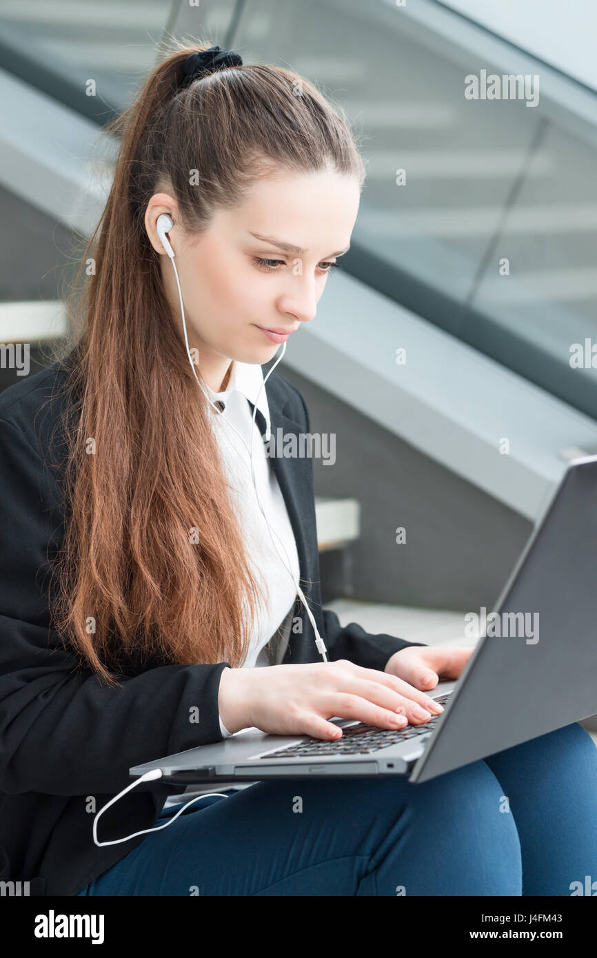 Business Woman sitting on stairs et working on laptop Banque D'Images