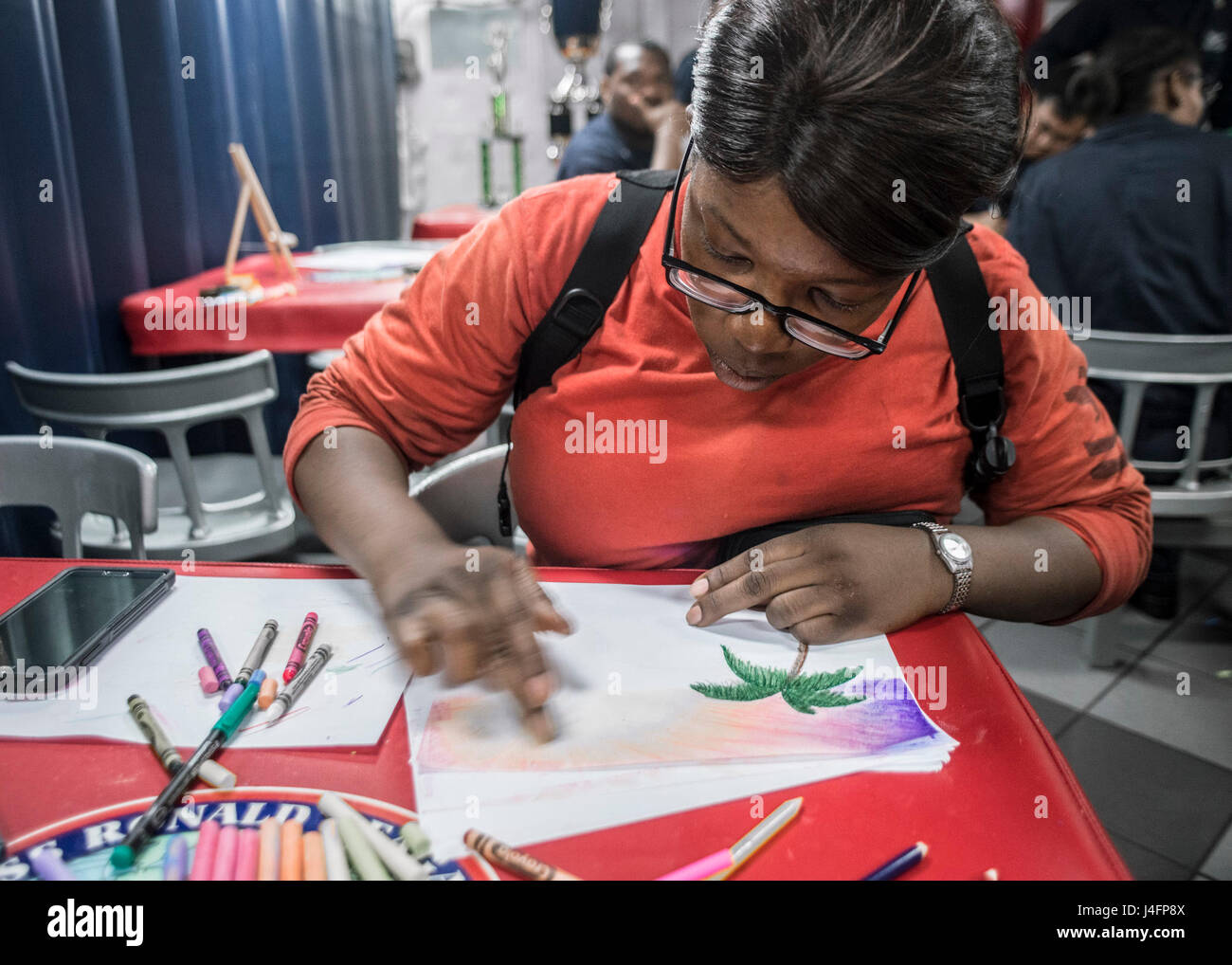 160704-N-IN729-098 Mer de Chine du Sud (4 juillet 2016) l'Aviation Ordnanceman 2e classe Jessica Robinson, à partir de mélanges de Baltimore, craie et crayon pendant un événement de peinture à bord de la Marine est qu'avant-déployé porte-avions USS Ronald Reagan (CVN 76) le jour de l'indépendance. "La coloration, ou quoi que ce soit, est vraiment créatif thérapeutique", a déclaré Robinson. "Il suffit de regarder autour et voir la concentration sur le visage de tout le monde et comment ils se perdent dans la couleur. Bob Ross était l'un d'un genre heureux dans son état d'esprit, et j'ai voulu venir et voir tout le monde la peinture et voir les choses qu'ils proposent." Ronald Reagan, Banque D'Images