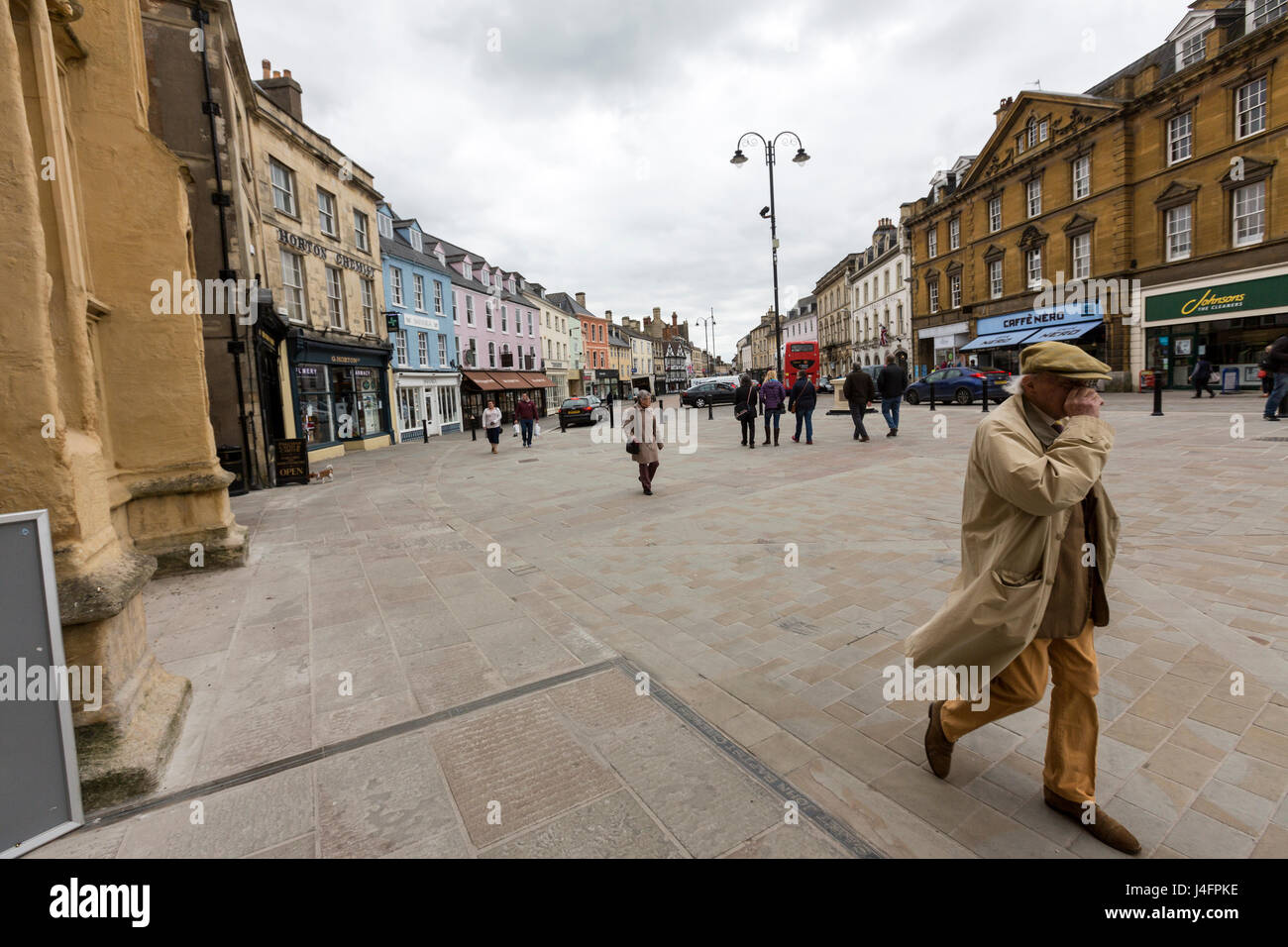 Man Walking in Market Place, Cirencester, Gloucestershire, Angleterre Banque D'Images