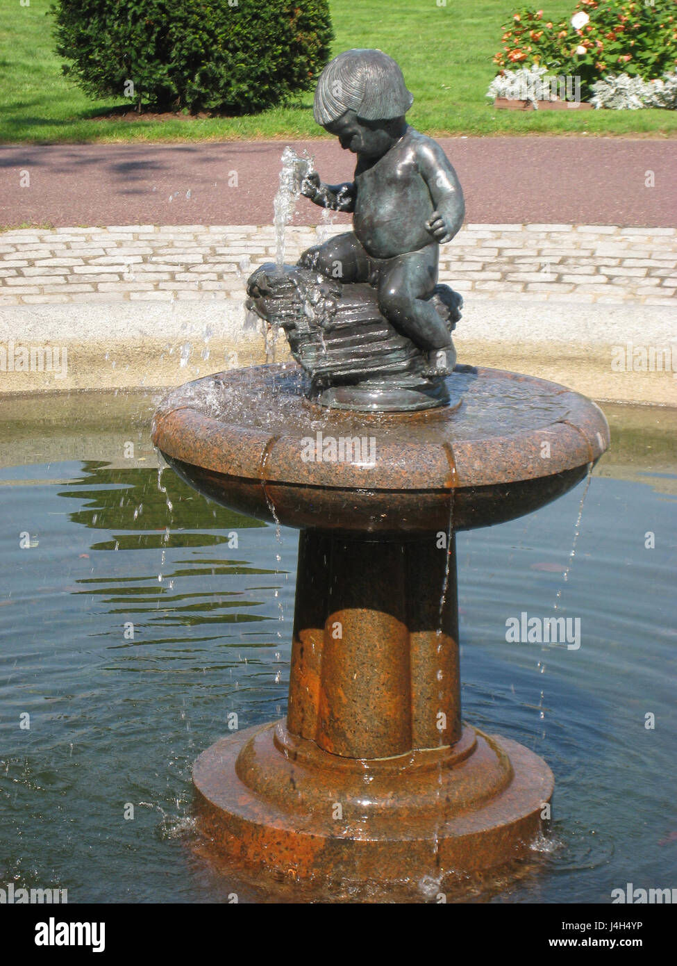 Une statue d'un petit enfant près d'une fontaine dans le jardin public de Boston, présentant l'art public dans le jardin emblématique. Banque D'Images Une statue d'un petit enfant près d'une fontaine dans le jardin public de Boston, présentant l'art public dans le jardin emblématique. Banque D'Images