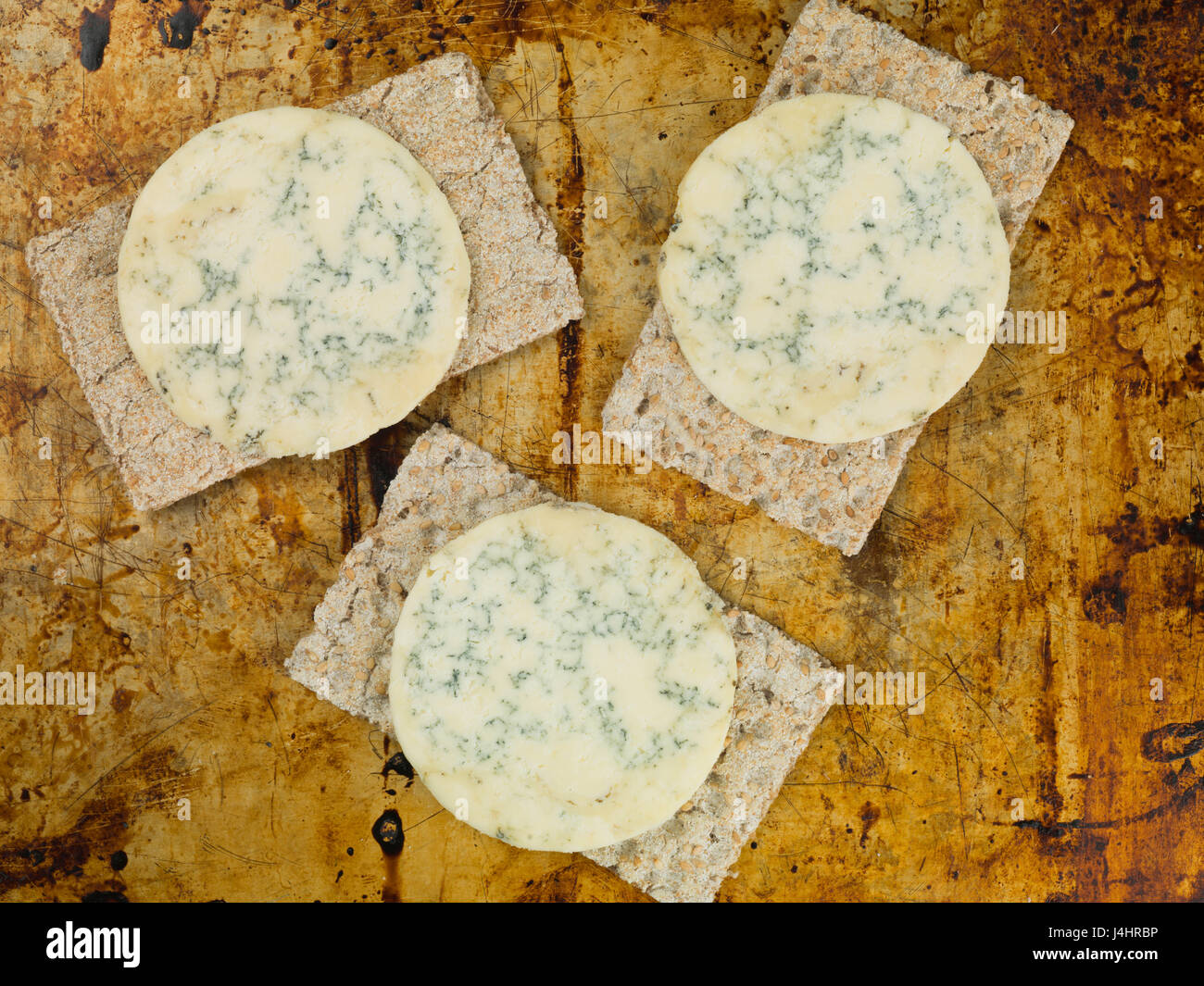 Le fromage stilton bleu vif sur une fine couche de biscuits complet sur un plateau de four Banque D'Images