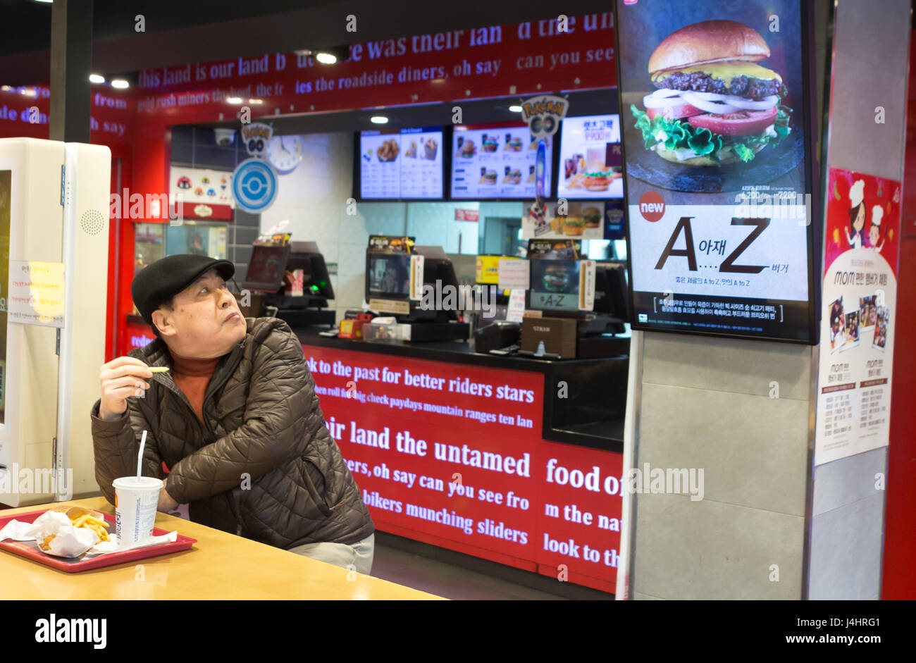 Busan, Corée du Sud - Mars 27th, 2017 sud-coréen : homme à l'intérieur d'un fast-food à la hamburger publicité. Banque D'Images