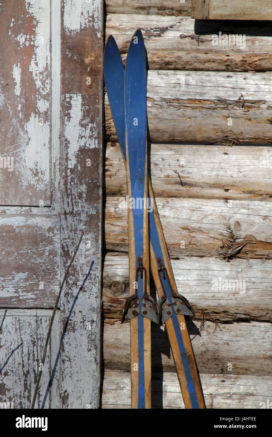 Skis de fond antique laissant contre le mur d'une vieille cabane en bois. Banque D'Images