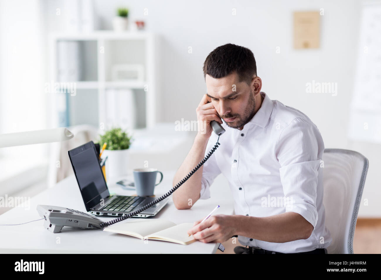 Businessman avec tampon appelant phone at office Banque D'Images