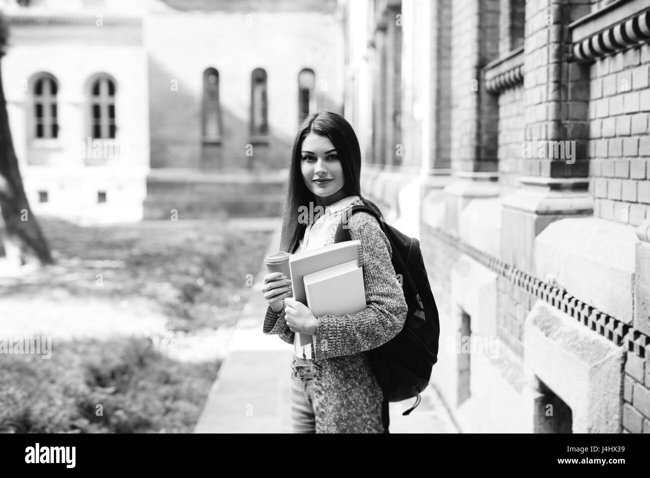 Smiling female student portables avec piscine près de l'université Banque D'Images