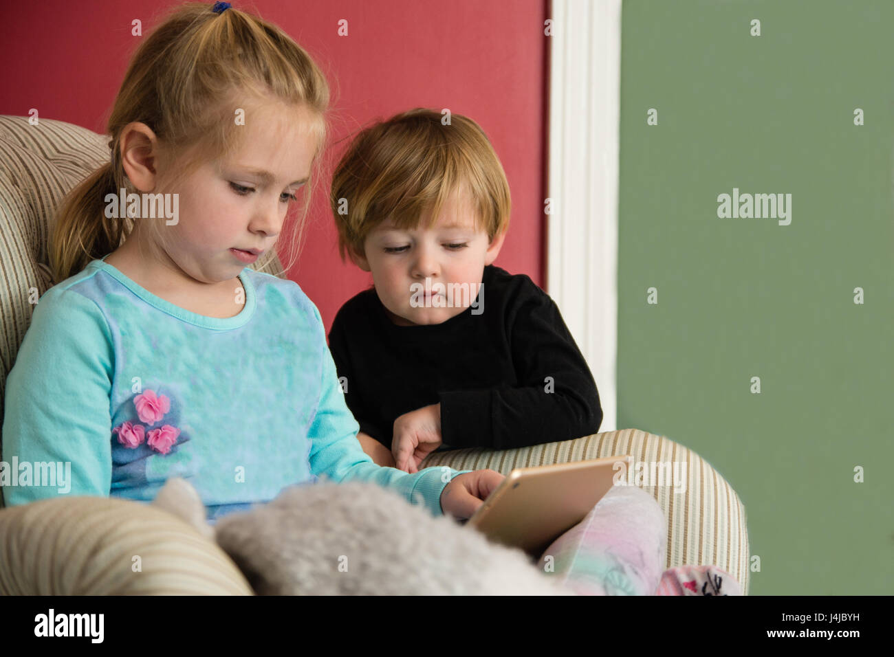 Frère et sœur jouant sur tablette électronique ensemble Banque D'Images