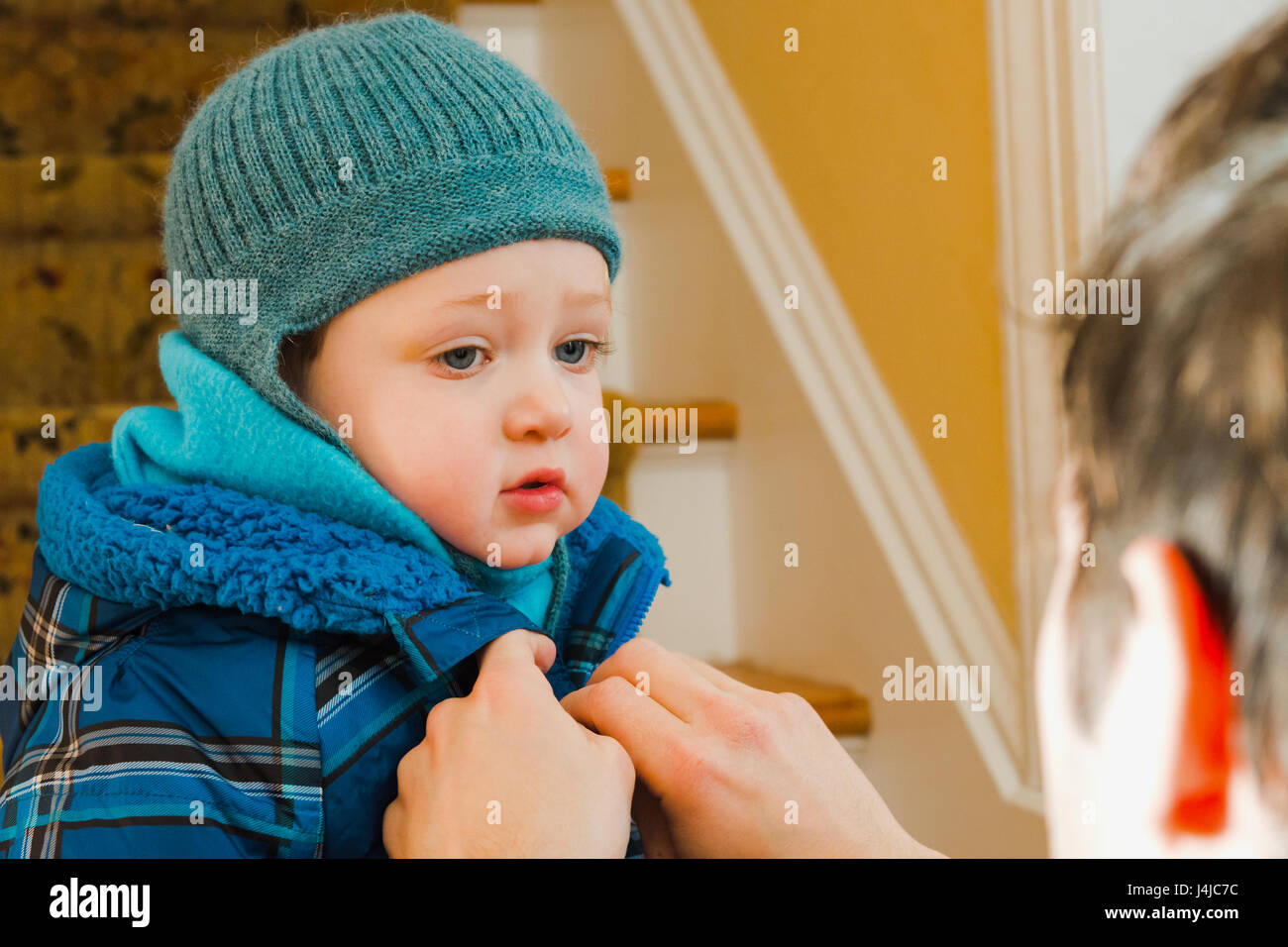 Père zipping up manteau d'hiver pour fils Banque D'Images