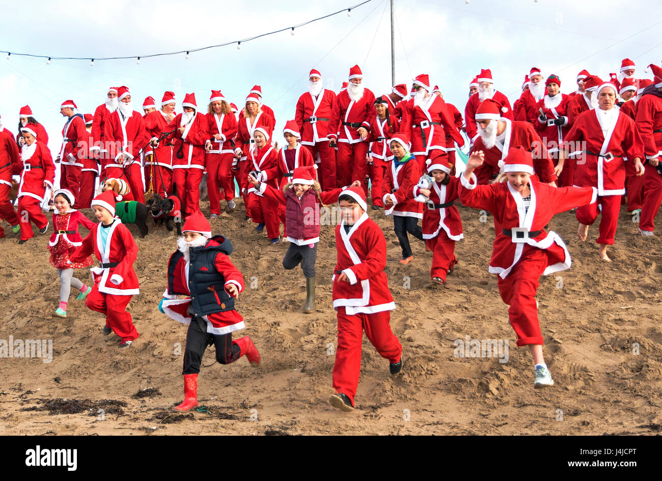 Broad Oak, Cornwall, UK. Au 18 décembre 2016. Santa's sur le sable d'un organisme de bienfaisance annuel exécuté sur Broad Oak beach à Cornwall, UK Banque D'Images