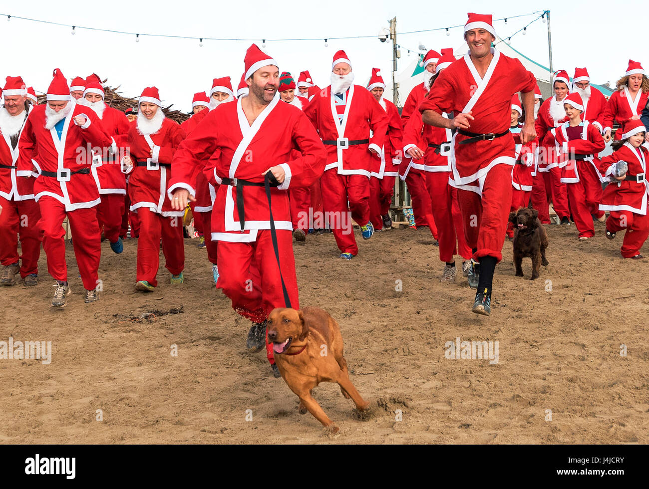 Broad Oak, Cornwall, UK. Au 18 décembre 2016. Santa's sur le sable d'un organisme de bienfaisance annuel exécuté sur Broad Oak beach à Cornwall, UK Banque D'Images