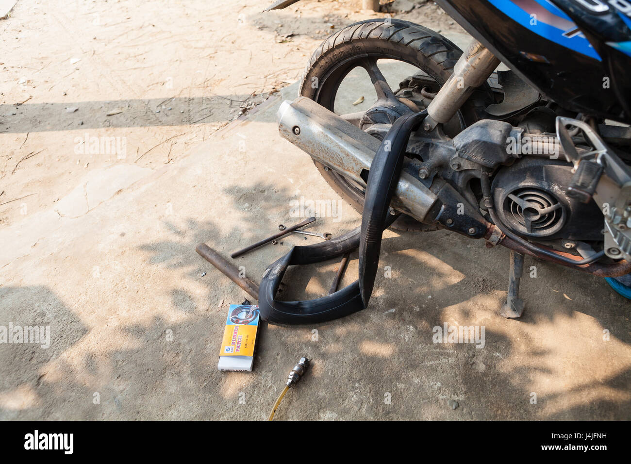 Hoi An, Vietnam - Mars 13, 2017 : réparation à l'innertube scooter local mécanicien, Vietnam Banque D'Images