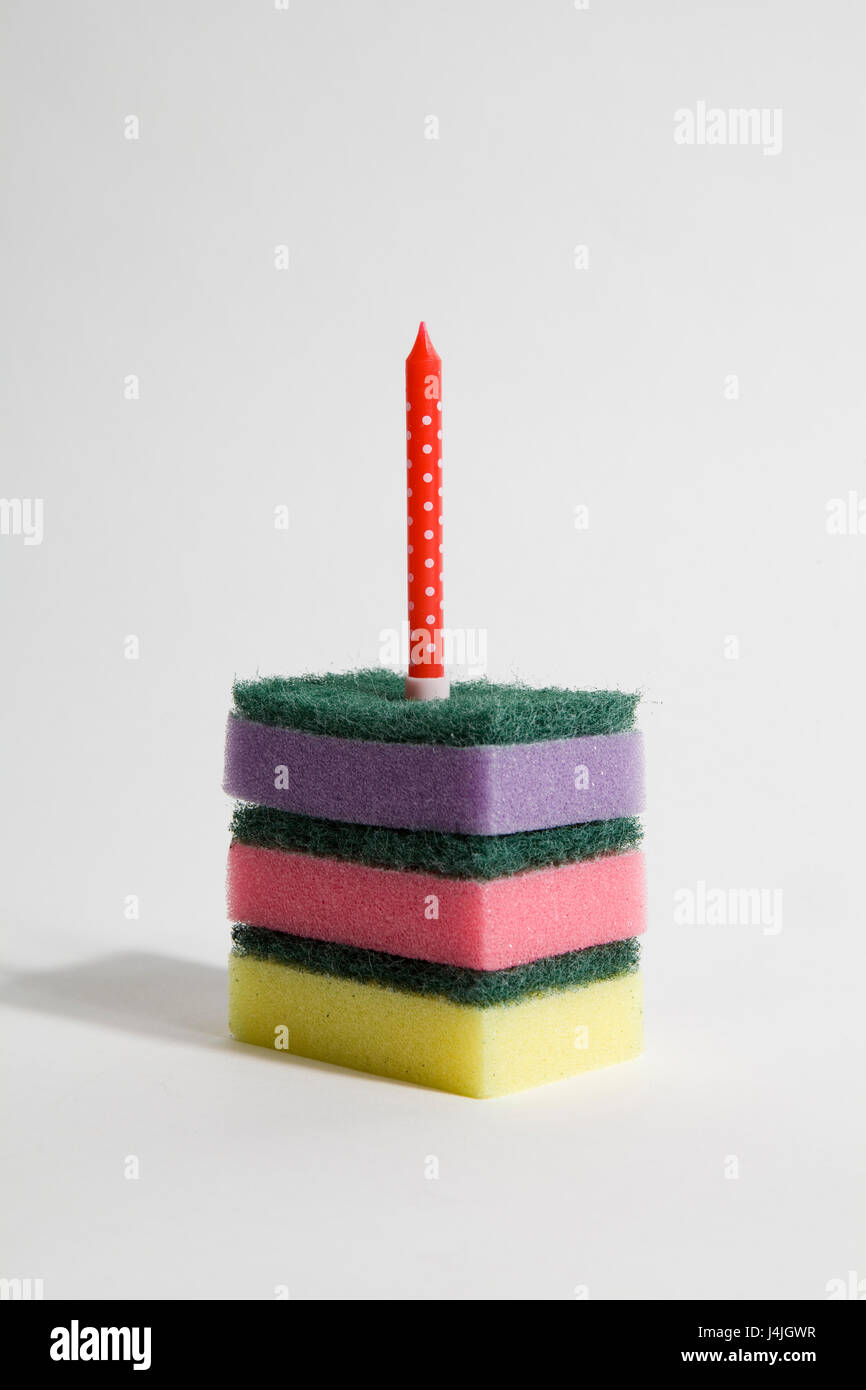 Une pile d'éponges multicolores avec une bougie symbolisant un morceau de gâteau d'anniversaire. couleur minimal pop et décalé et excentrique, la photographie. Banque D'Images